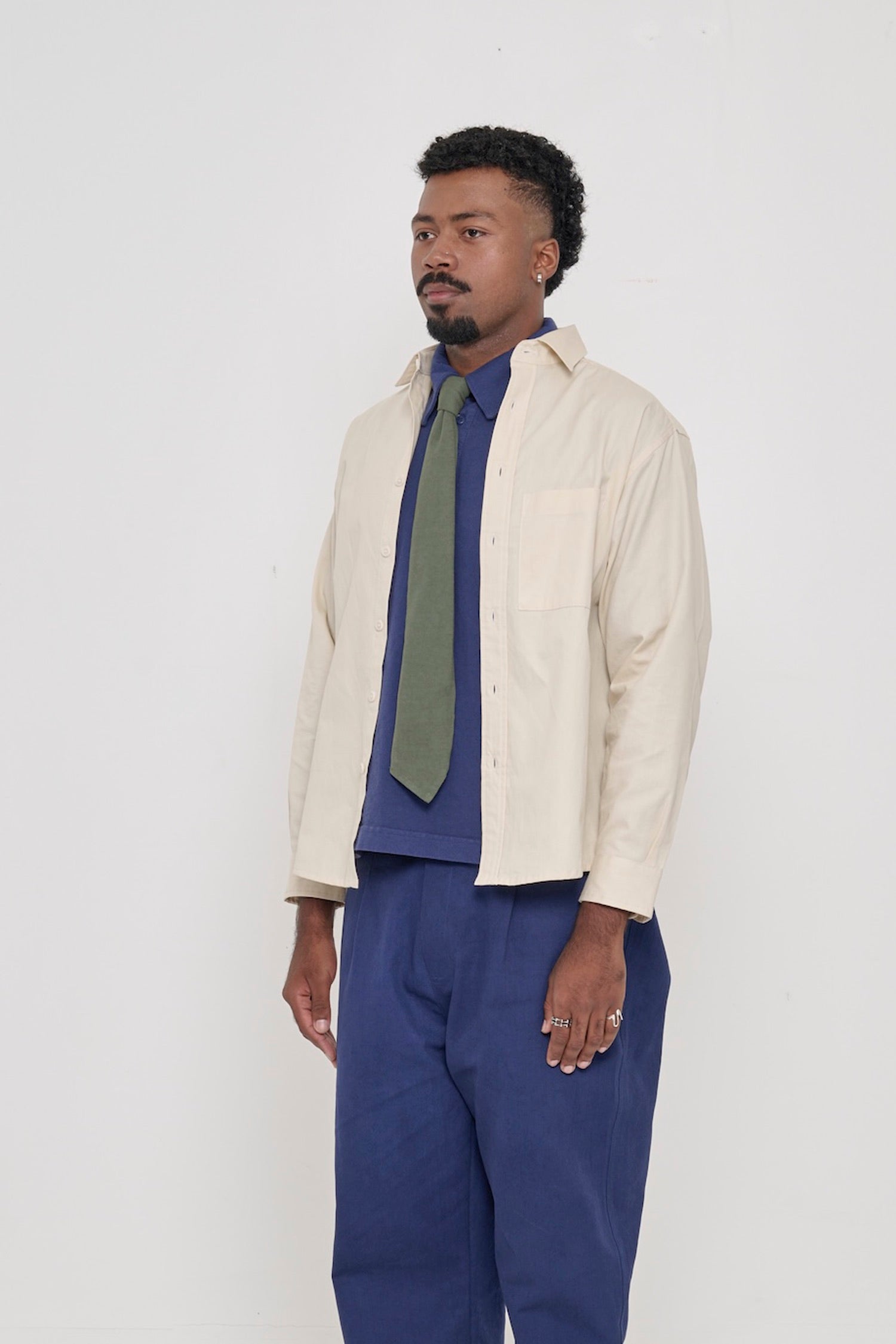 A person in a Oat Peach Fuzz Twill Button Up Shirt in a 3/4 front view, highlighting the shirt's sleeves.