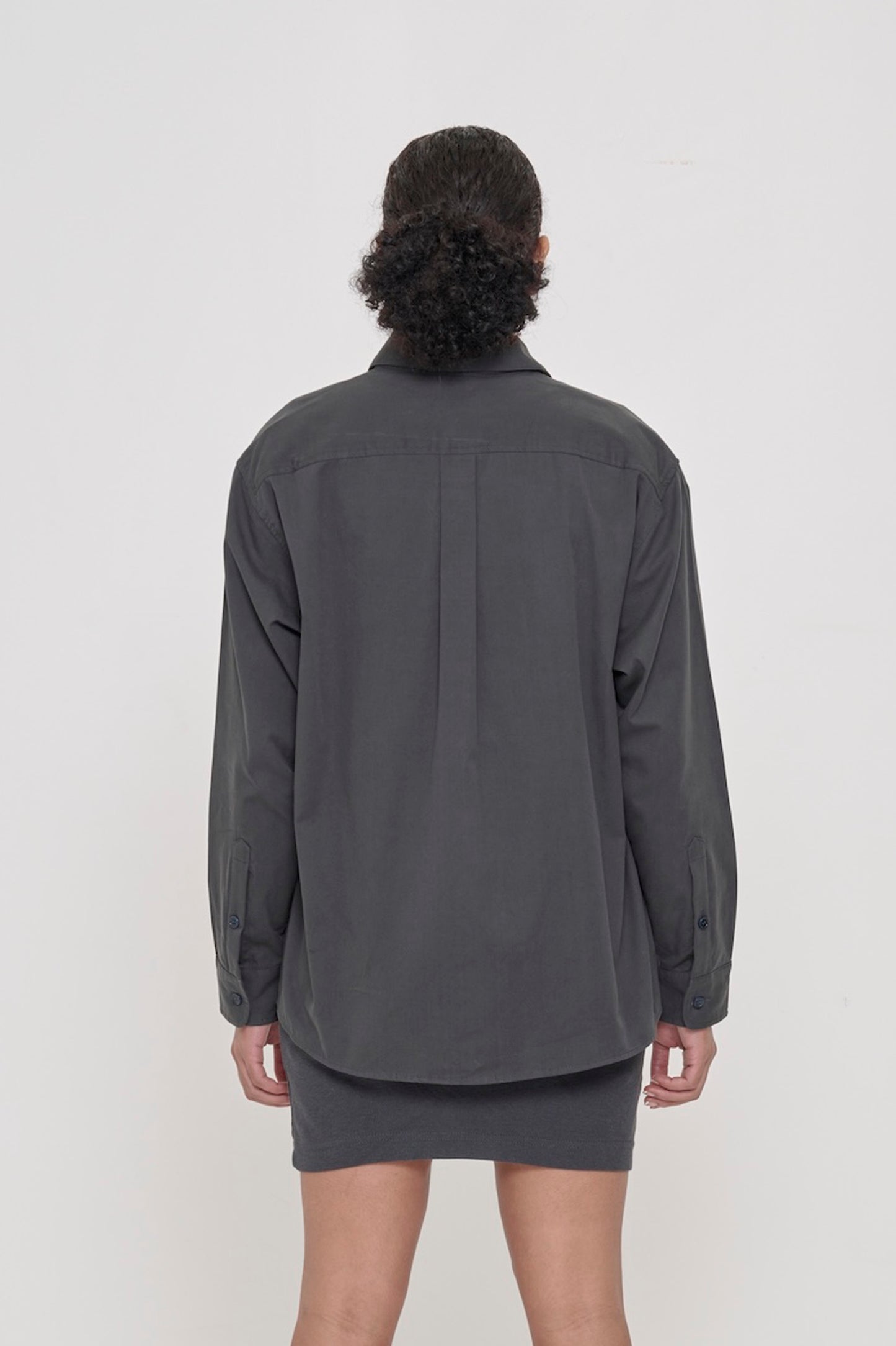 Back view: A person in a Slate Peach Fuzz Twill Button Up Shirt. Shows the relaxed drape of the fabric and box pleat at yoke.