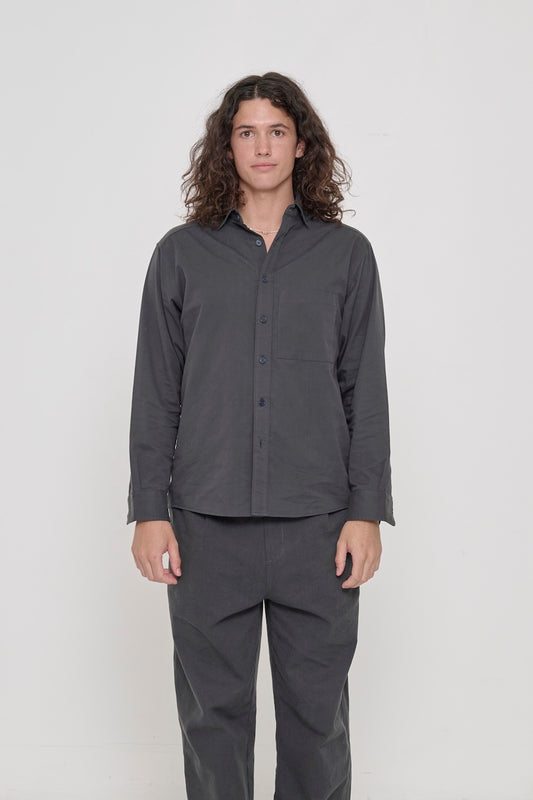 Person in a Slate Peach Fuzz Twill Button Up Shirt, buttoned up and worn with matching Cotton Twill Life Uniform Pants. 
