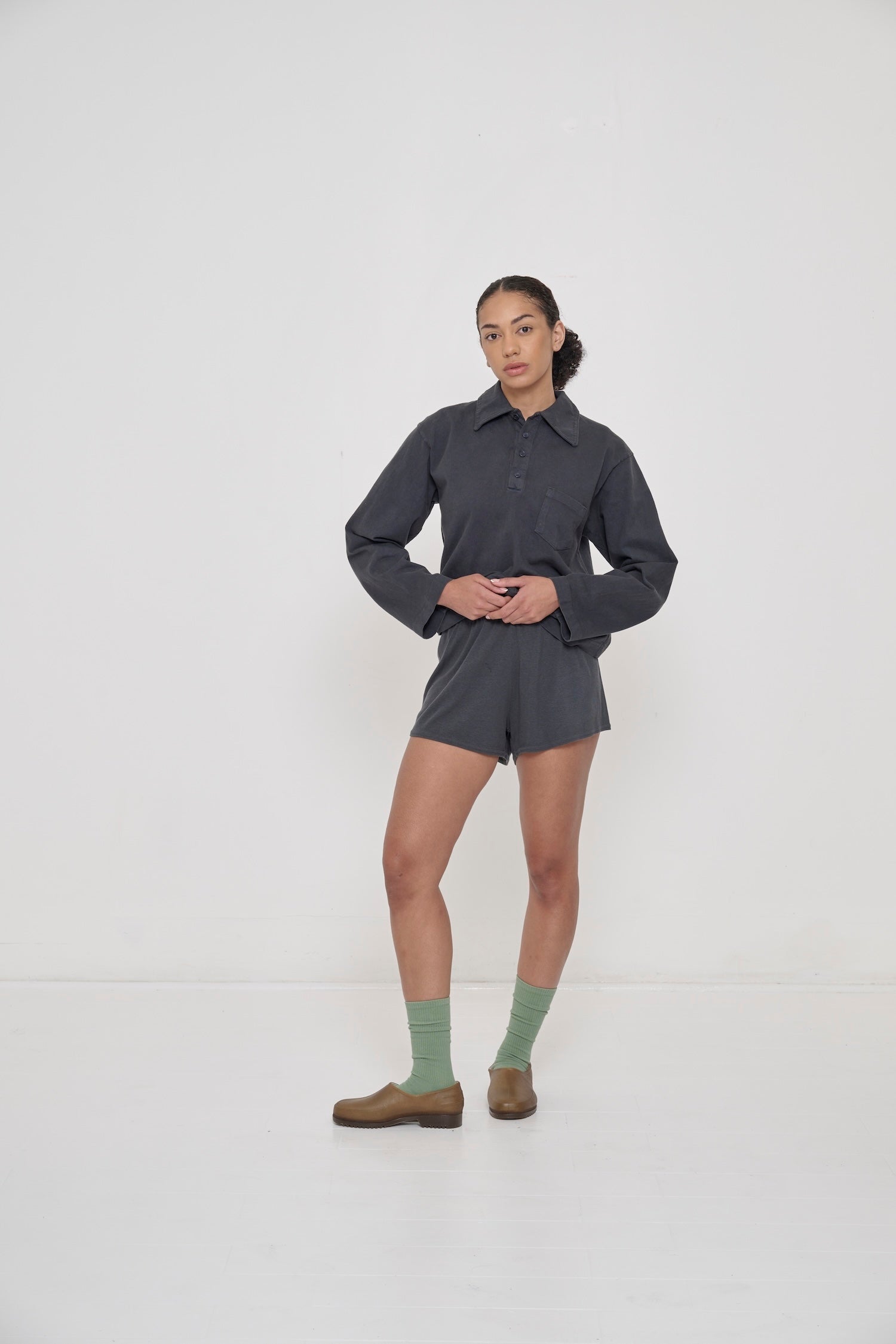 Model wearing Hemp Plasticana Gardana Clogs with Slate Rib Shorts, Slate Rugby Trash Polo and Wasabi Squishy Socks.