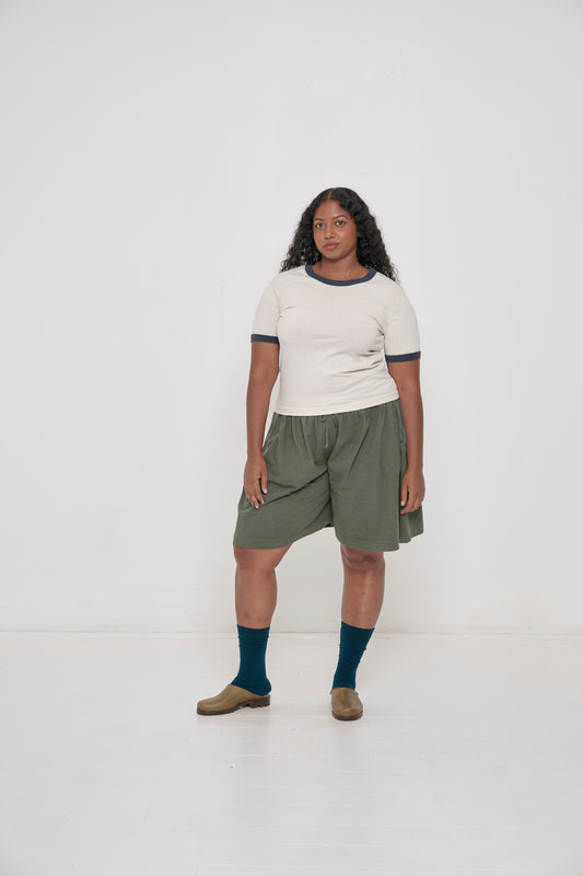 Model wearing Hemp Plasticana Opana Mules with Pine Long Tubular Shorts and Juniper Squishy Socks.