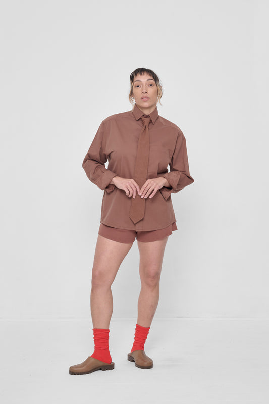 Styled with a Peach Fuzz Button-Up Shirt, a Trash Tie, and matching Rib Shorts.
