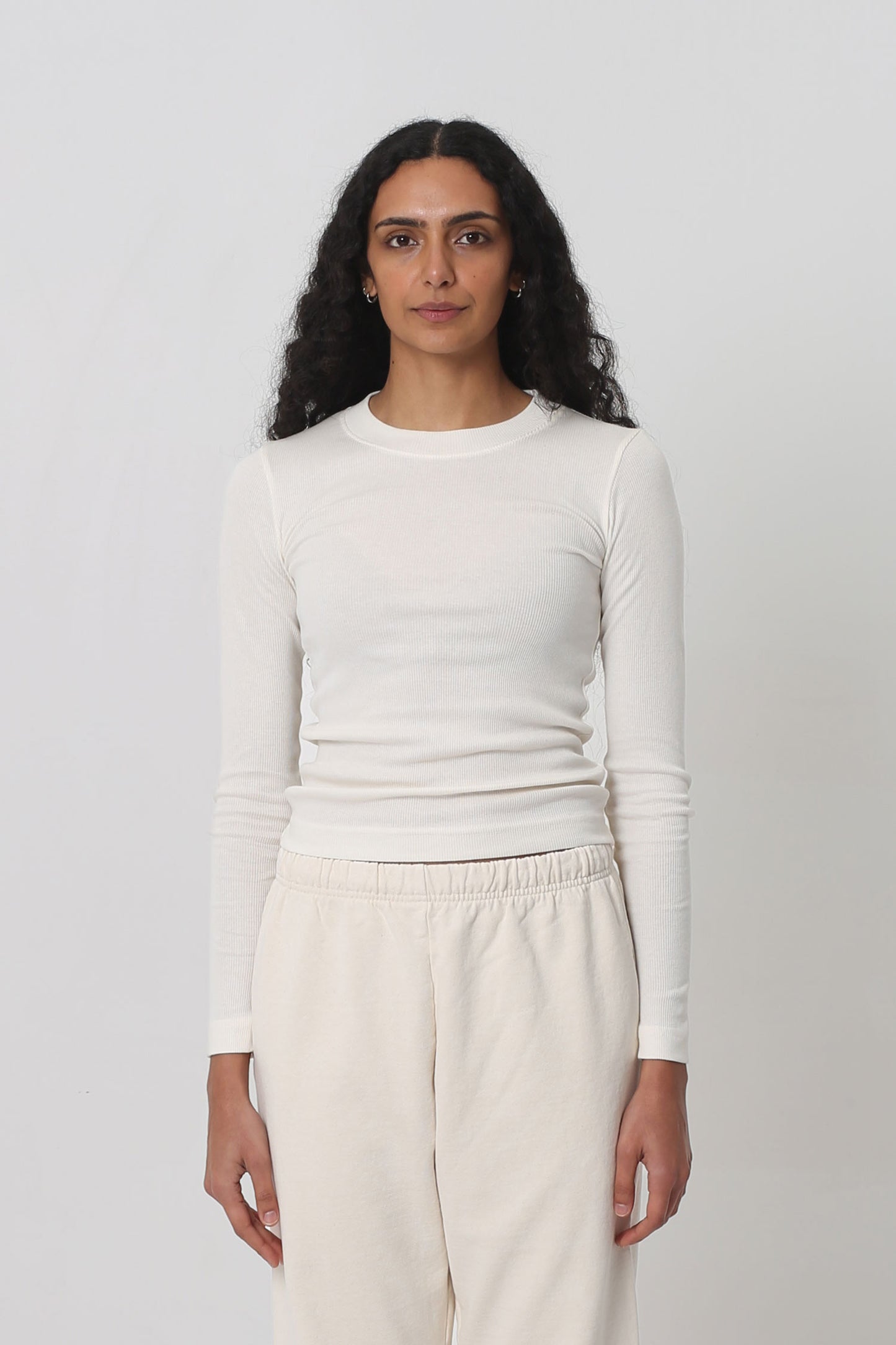 A 5'10" woman in a size S Natural Rib Long Sleeve. Hem at the top of her hips.