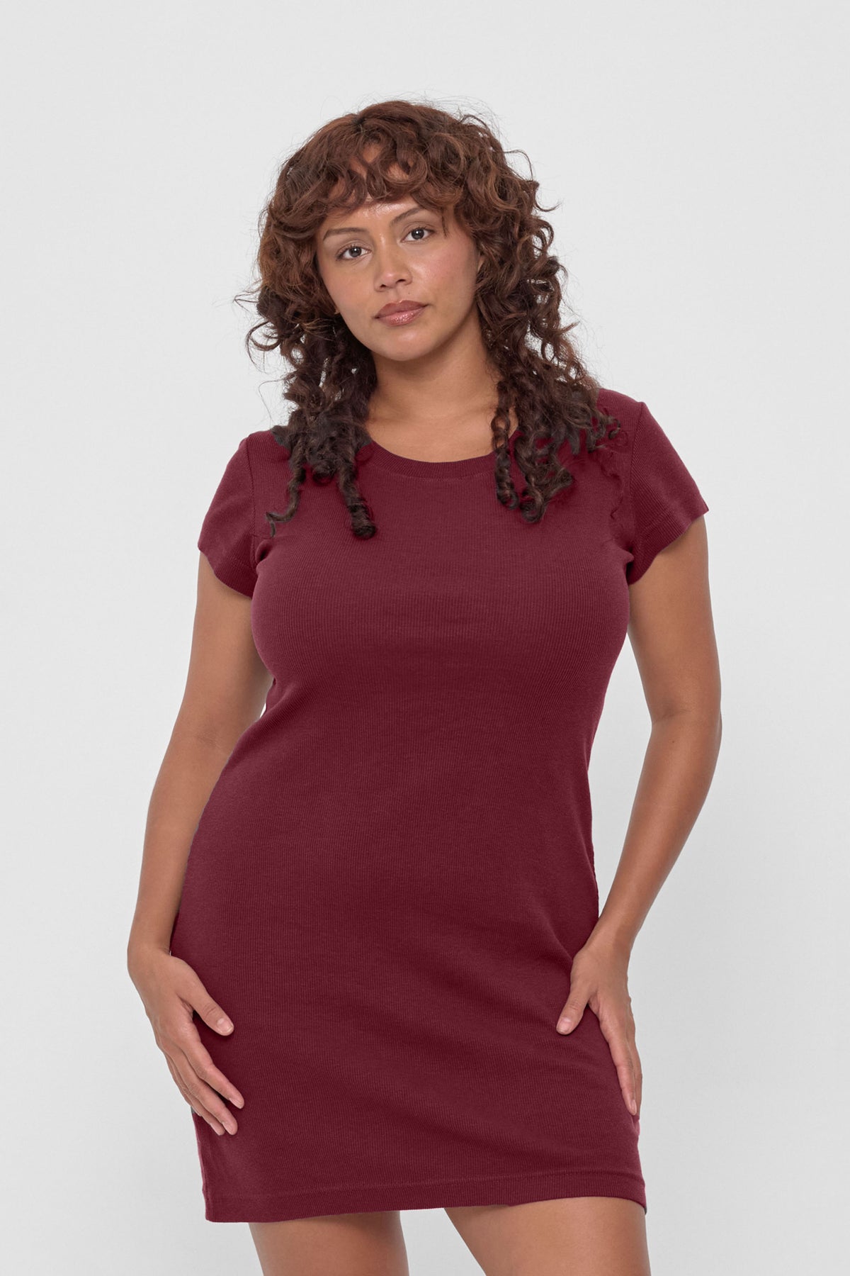 Rib Dress in Garnet – front view, model's hands on her hips