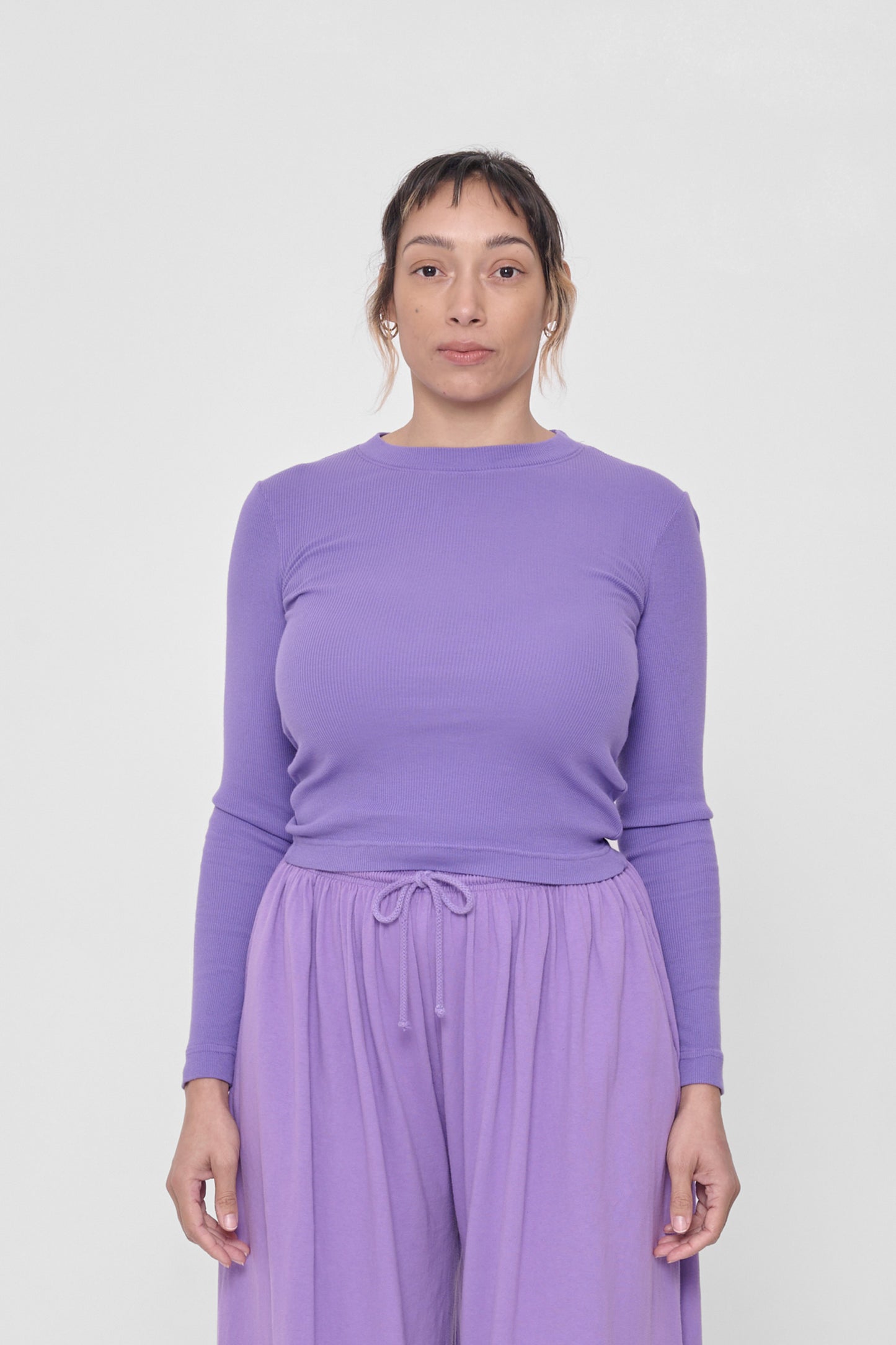 5'4" woman in a size S Carpe Diem Rib Long Sleeve. Hem rests above her hip bones.