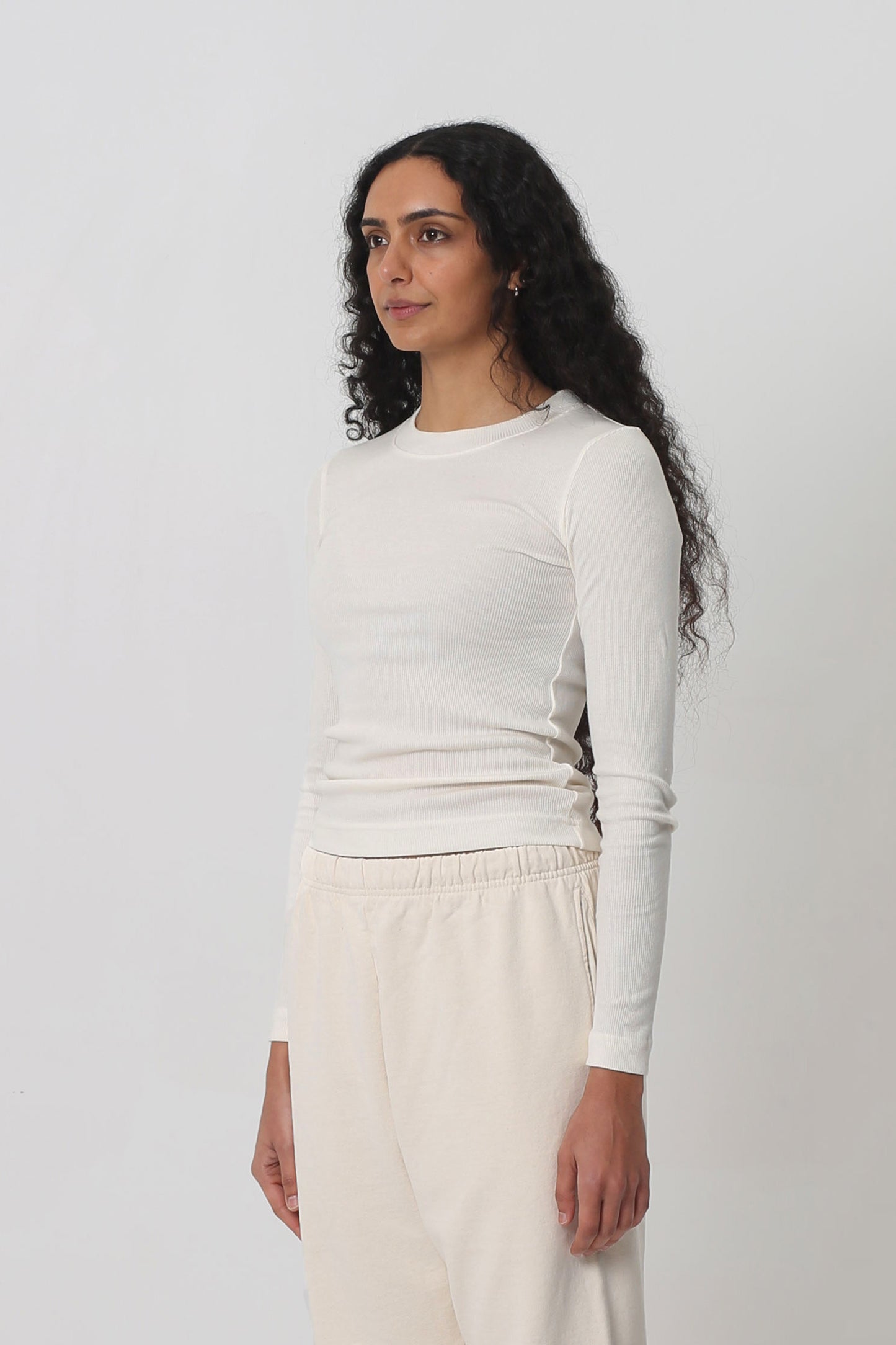 A person facing 45-degrees from the front shows side seams and fitted silhouette.