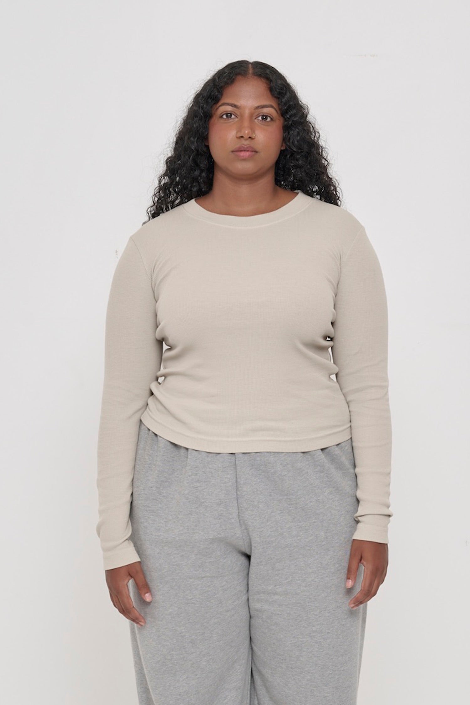 A 5'8" woman in a size M Oat Rib Long Sleeve. Hem hits the top of her hips.