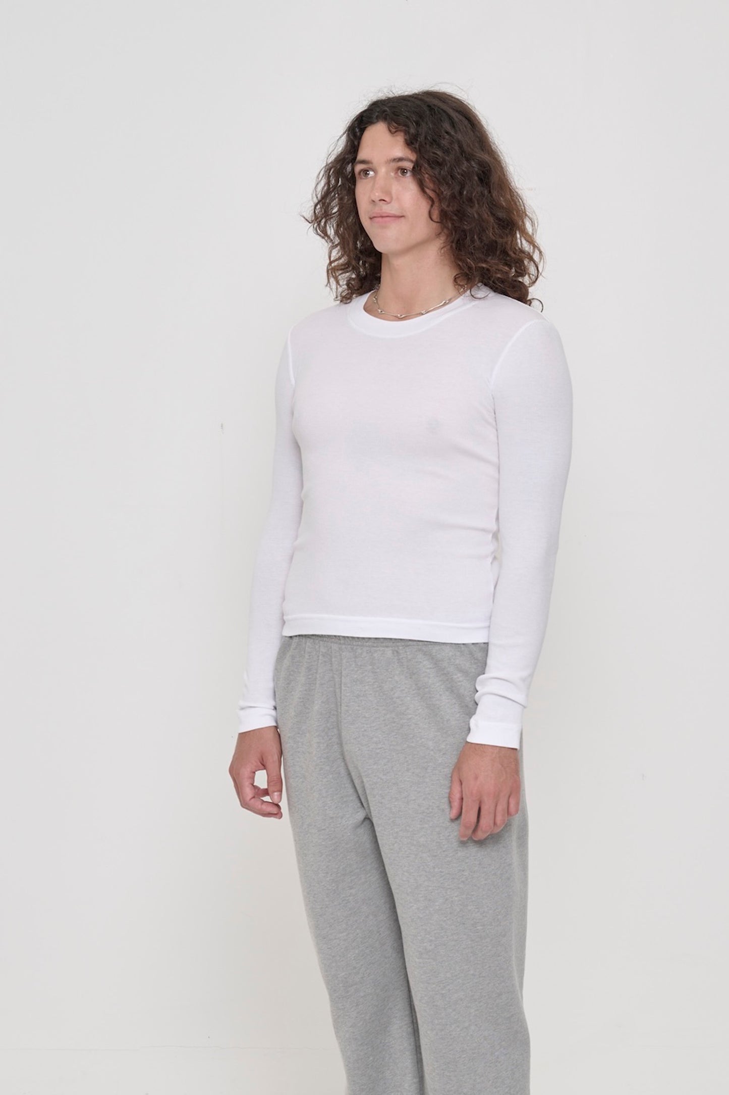 A person facing 45-degrees from the front, in a White Rib Long Sleeve, Shows side seams, heavy hem, and fitted silhouette.