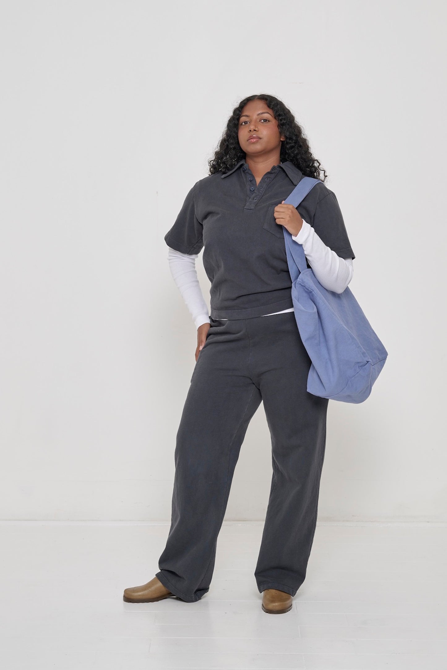 Rib Long Sleeve as a base layer: A woman in a Trash Polo layered over a White Rib Long Sleeve. A Big Tote on her shoulder.