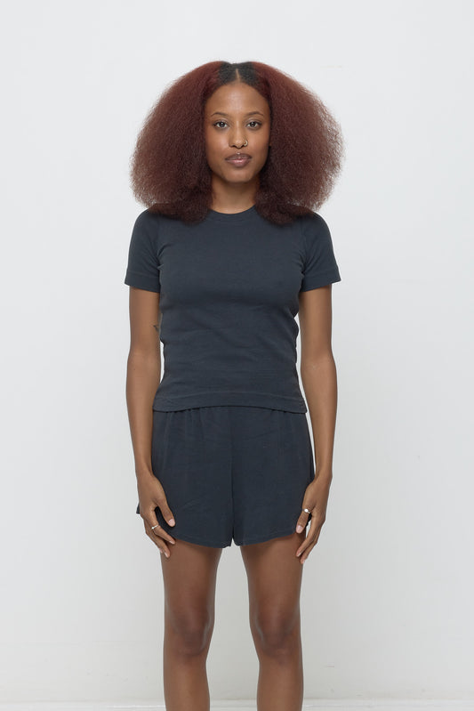 Front view of a 5'3" woman wearing a size S Rib Short Sleeve in Slate. Hem rests on her upper hips.