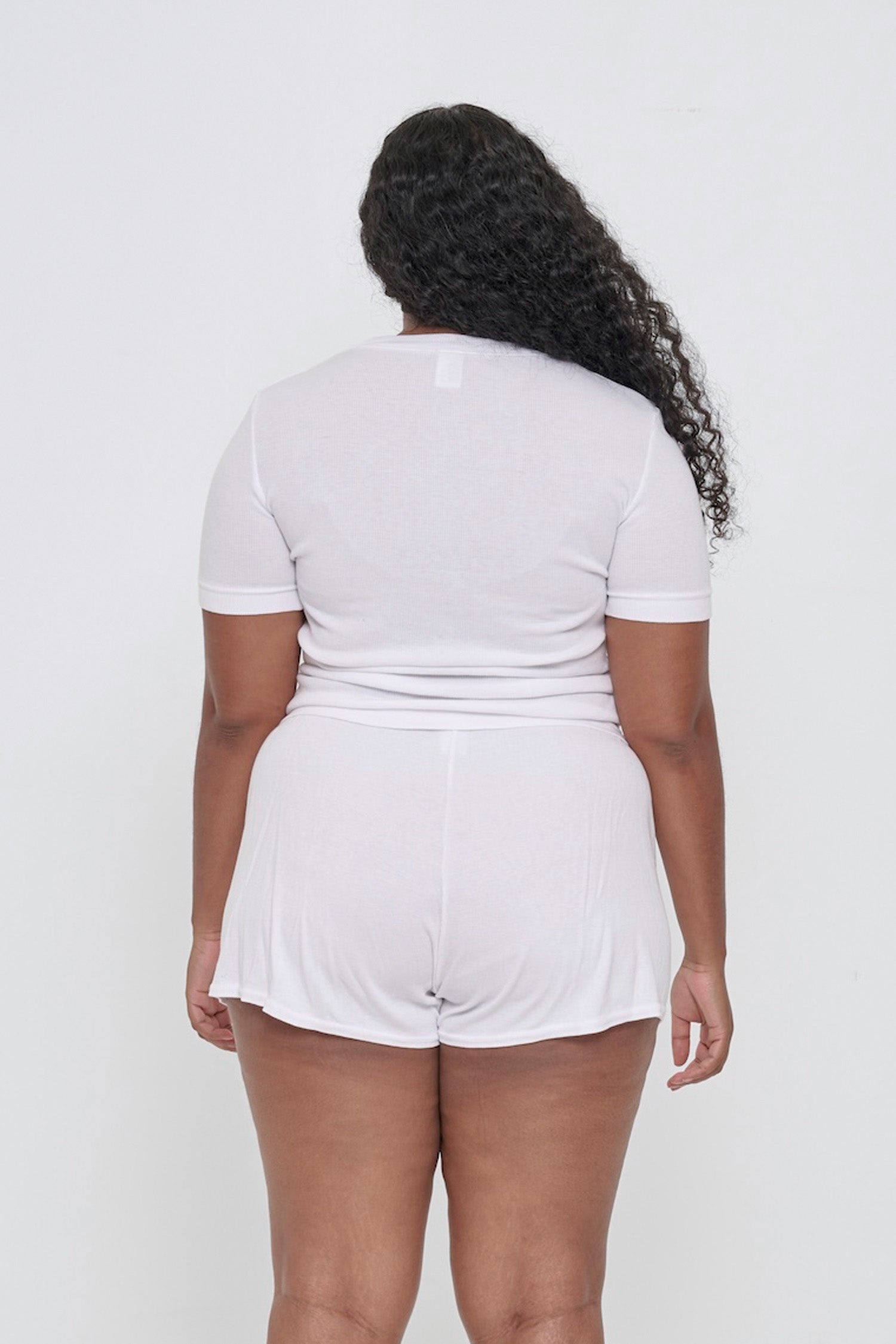 Back view: woman in White Rib Short Sleeve, showcasing the formfitting silhouette