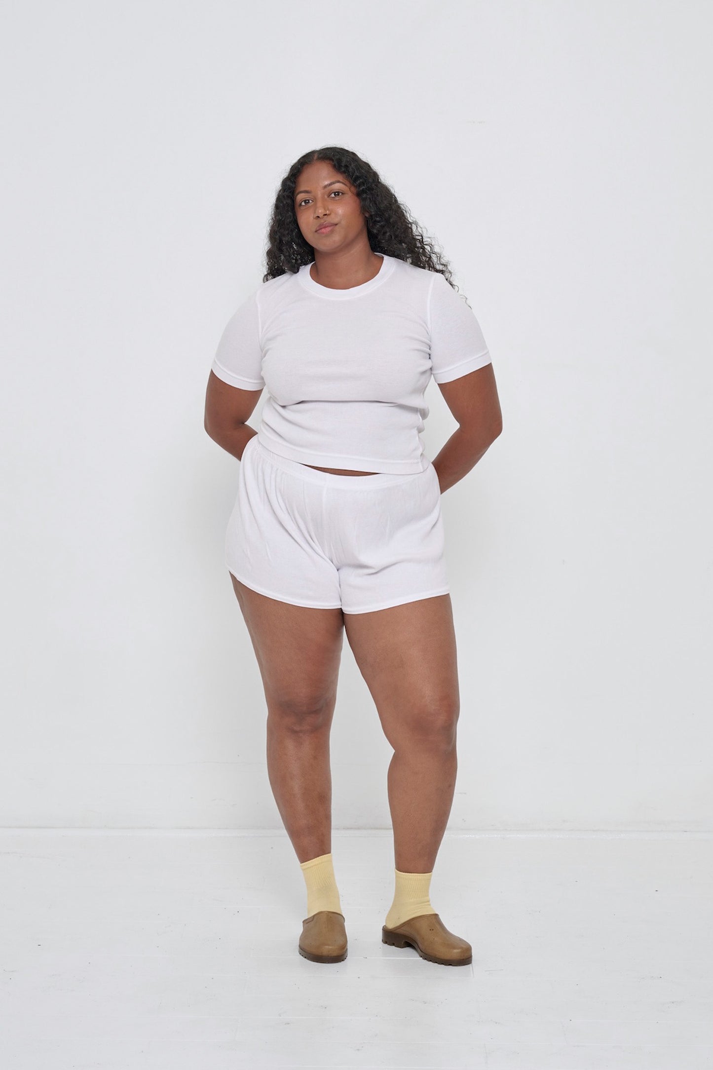 Woman in a White Rib Short Sleeve and matching Rib Shorts with Plasticana Opana Mules.