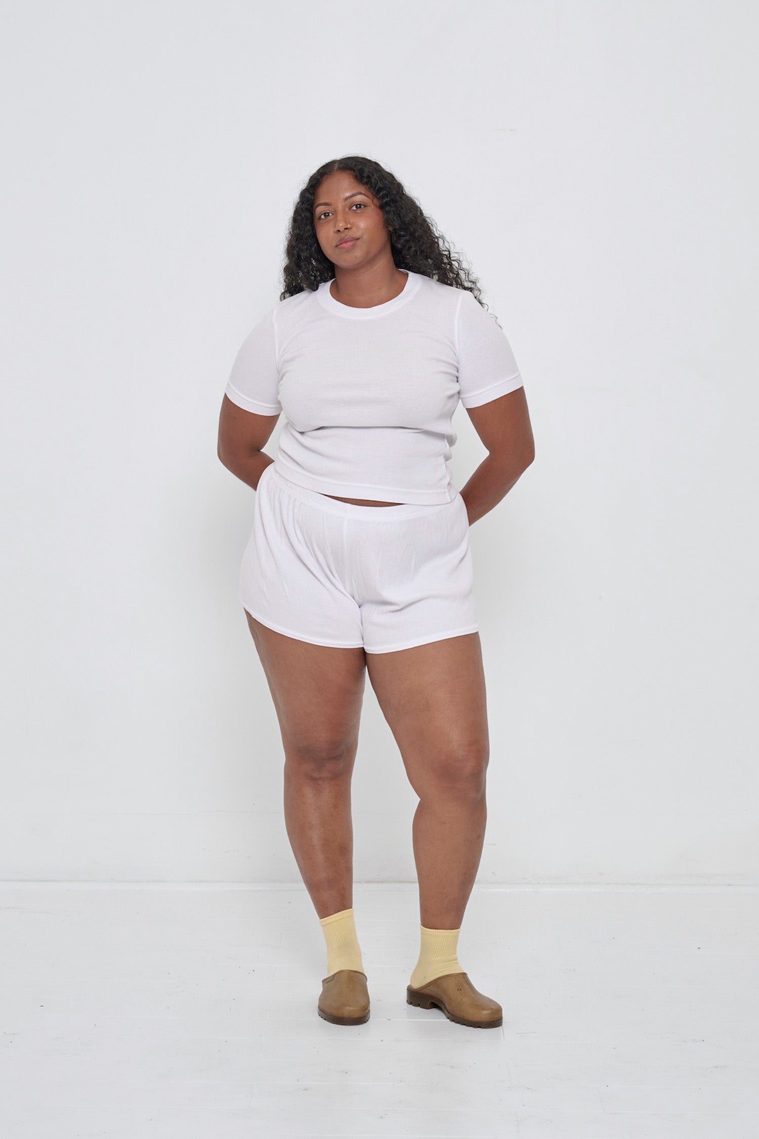 Woman in a White Rib Short Sleeve and matching Rib Shorts with Plasticana Opana Mules.