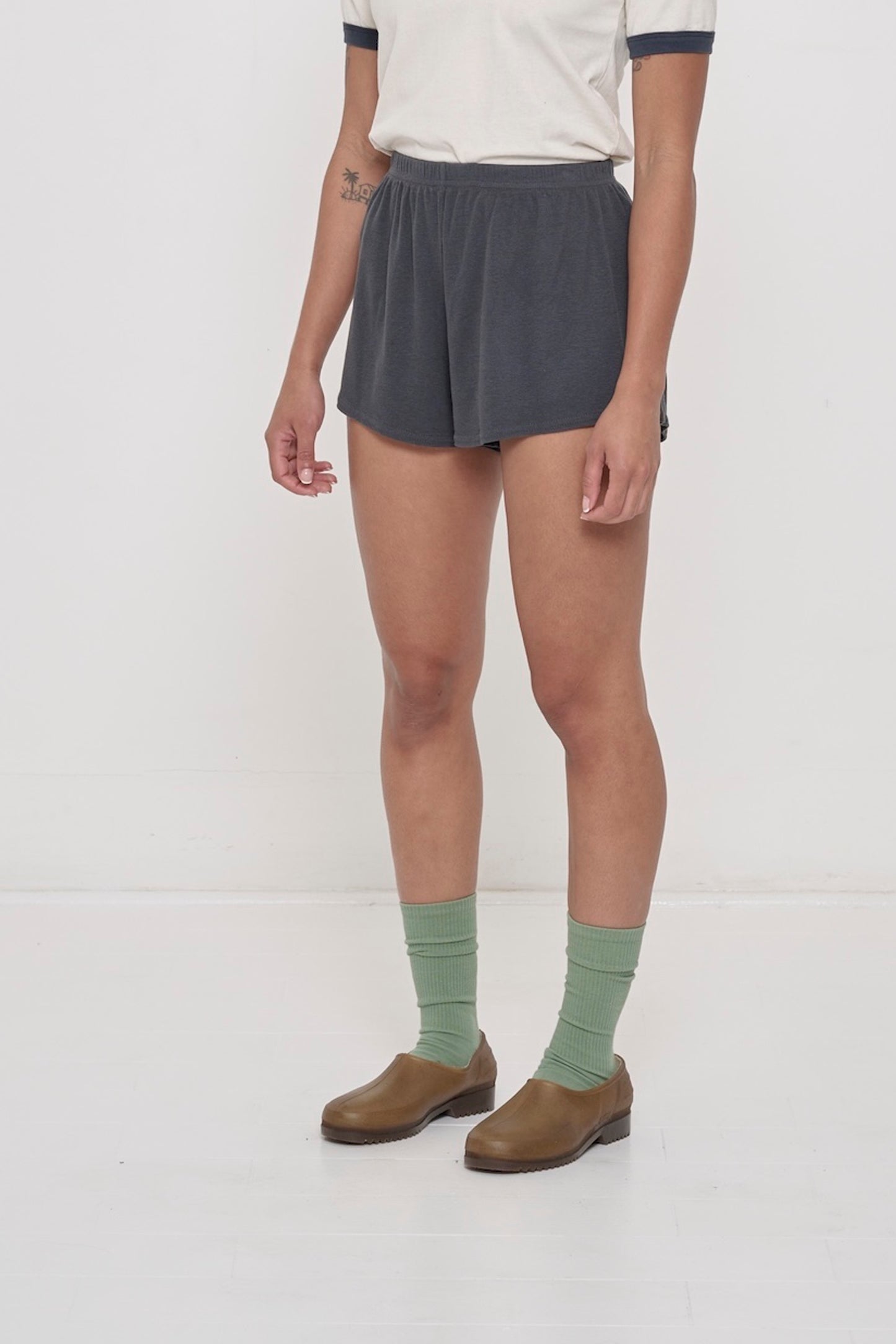 A person facing 45-degrees, wearing Slate Rib Shorts, showcasing spacious leg openings.