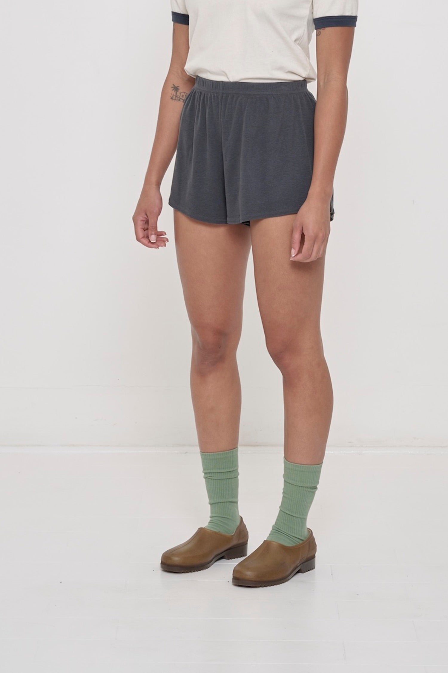 A person facing 45-degrees, wearing Slate Rib Shorts, showcasing spacious leg openings.