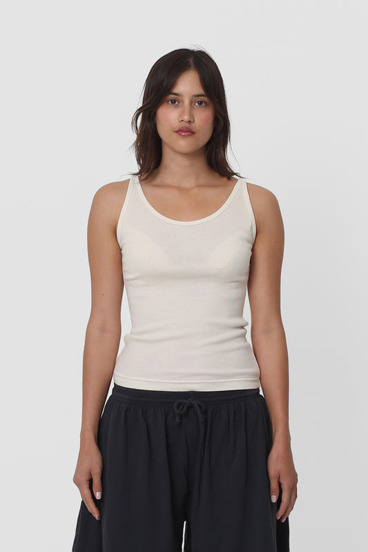 A woman in a Natural Rib Tank, the hem sitting above her Slate Long Tubular Shorts