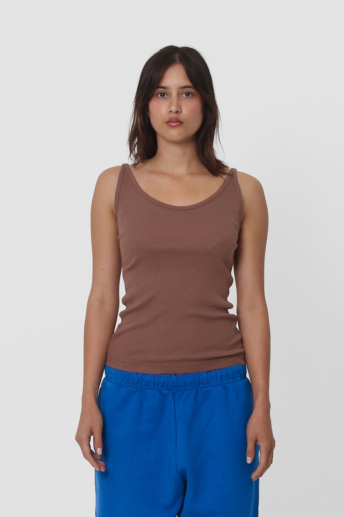 A woman in a Potting Soil Rib Tank, the hem sitting just above her Lapis Trash Sweatpants