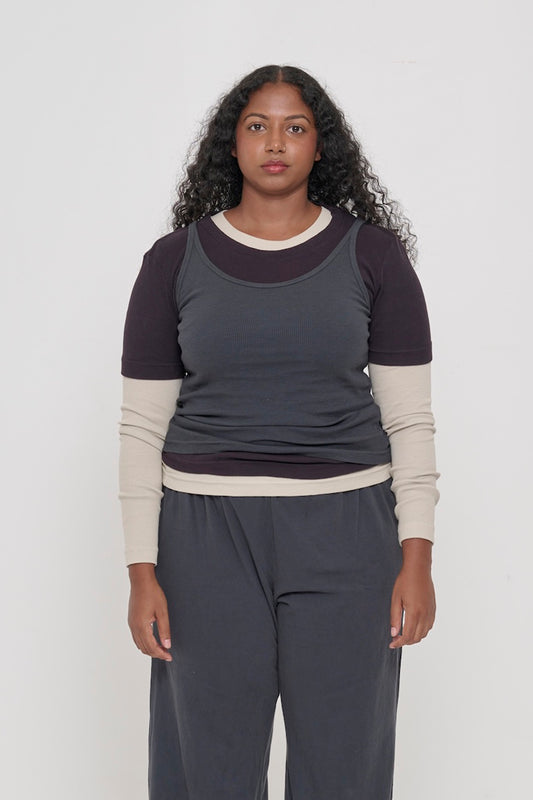 A 5'8" woman in a size L Slate Rib Tank. Hem is stylishly gathered just above her hips.