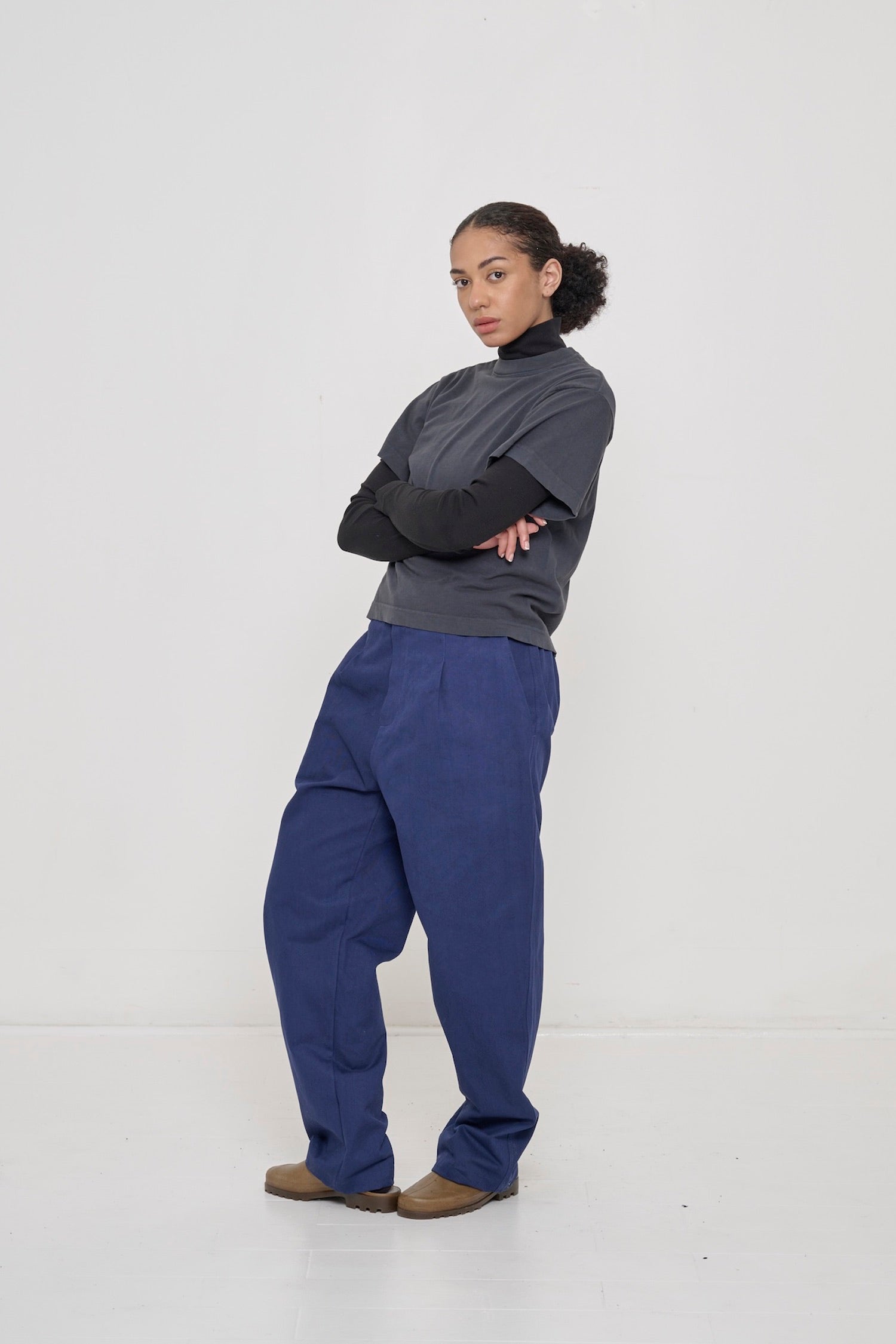 Woman wearing Black Rib Turtleneck under Slate Boxier Trash Tee and Washed Navy pants.
