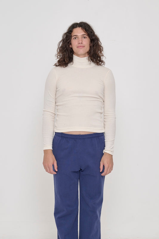 A 6' person in a size M Rib Turtleneck in Natural. Hem rests above their hips.