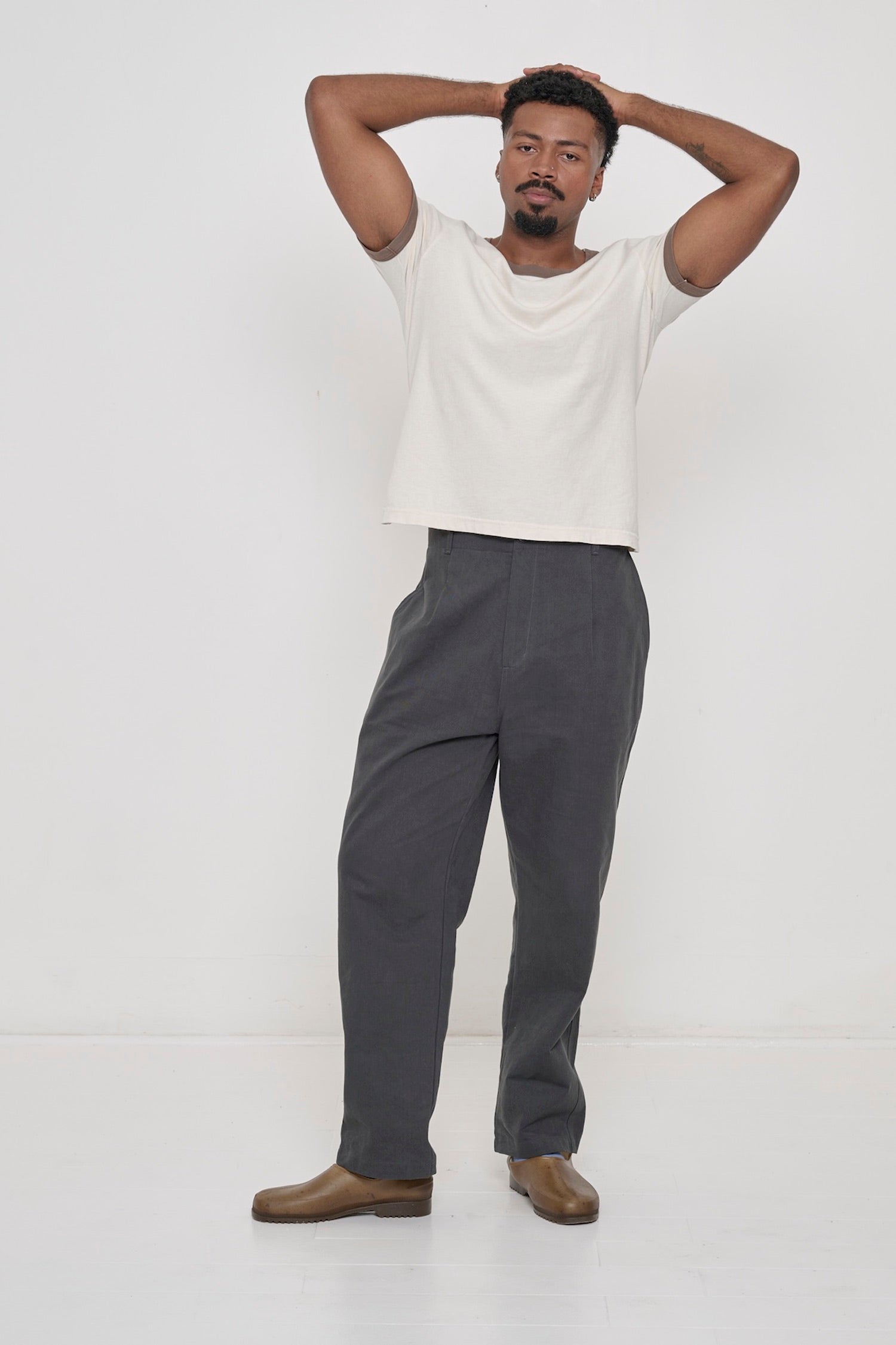 A man wearing a Dry Soil Ringer Trash Tee with Cotton Twill Life Uniform Pants in Slate.