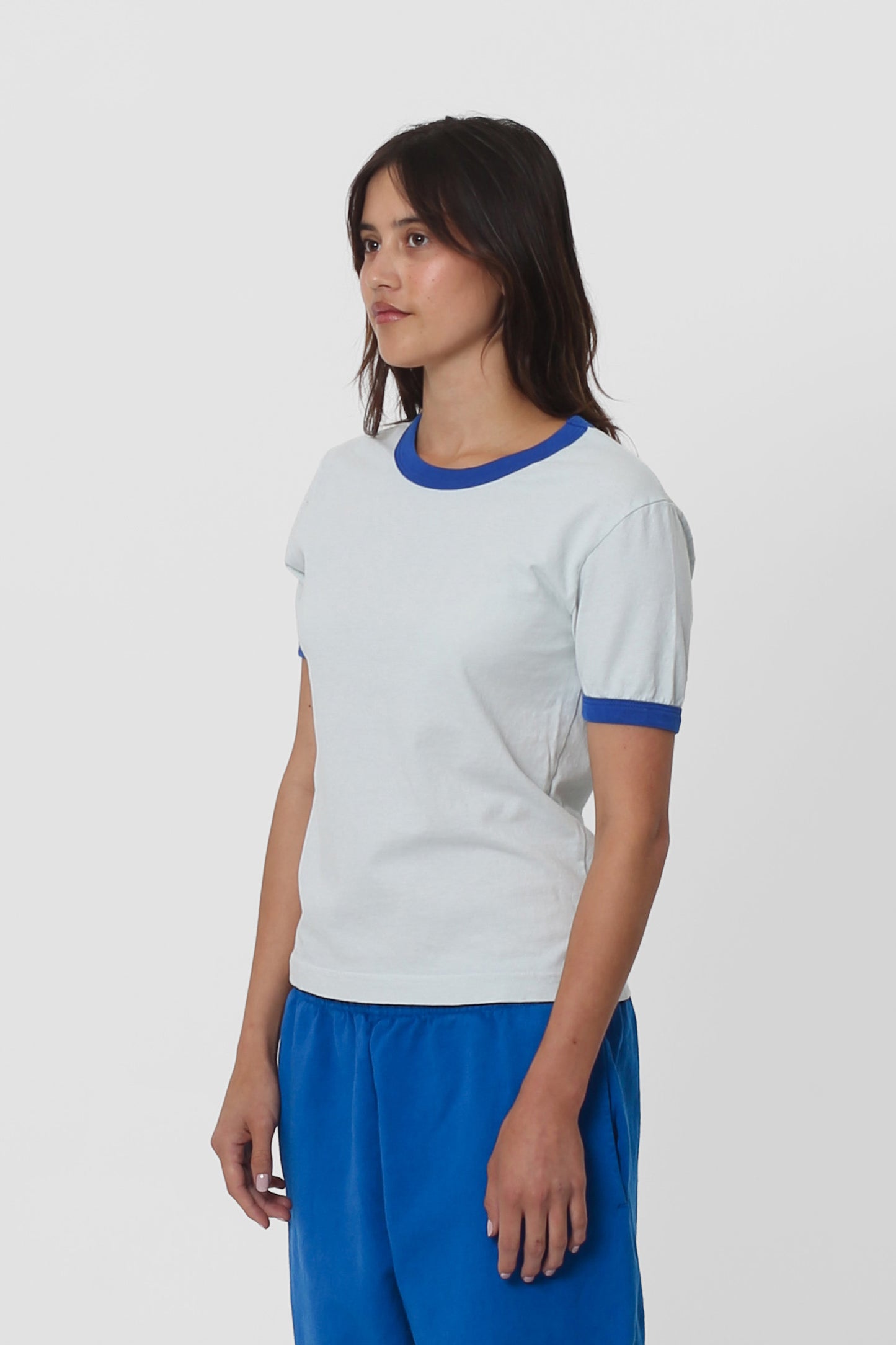 A woman turned 45-degrees from the front, showing the side seams and slim fit.