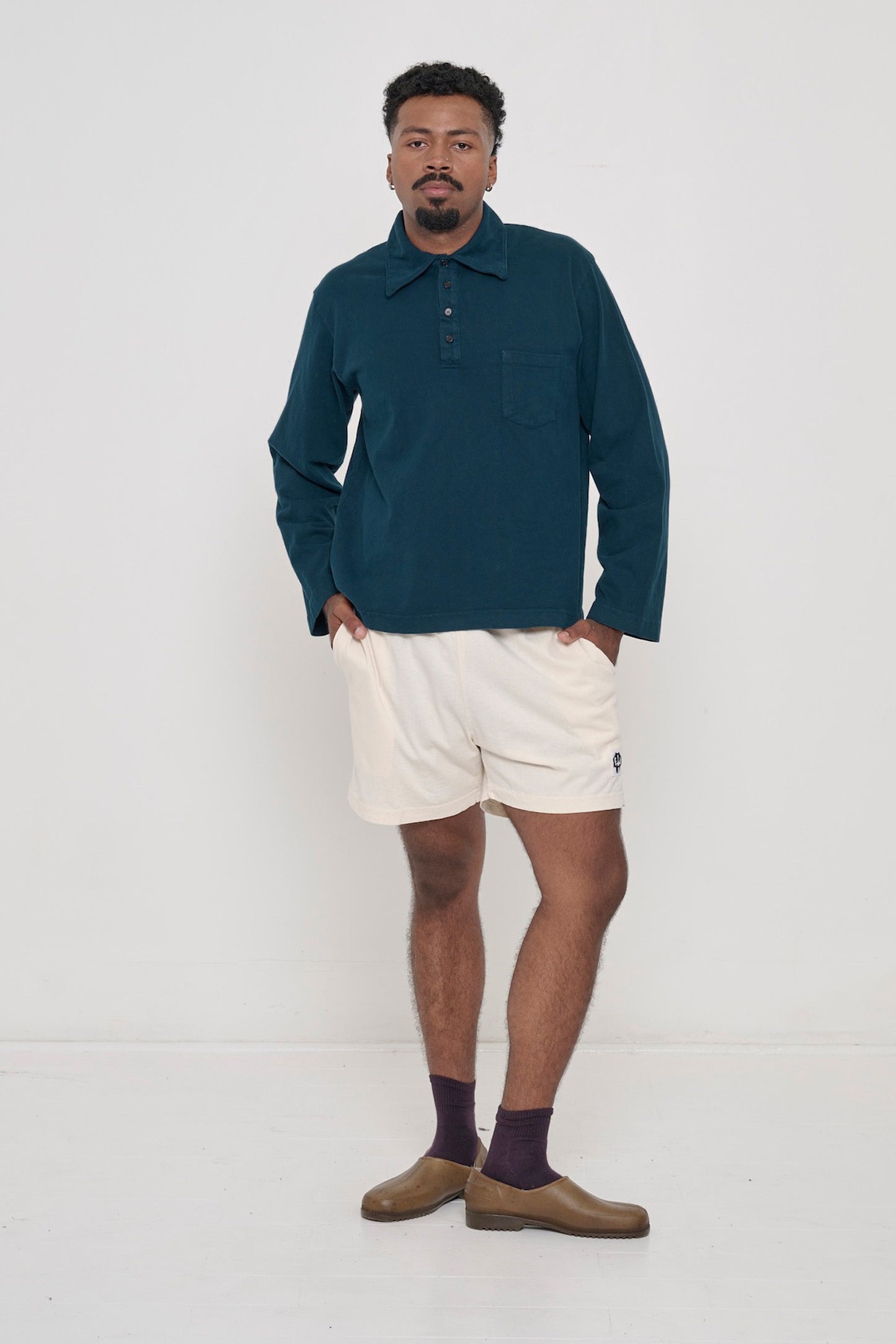 Person wearing Juniper Rugby Trash Polo with Scour Everyday Shorts. 