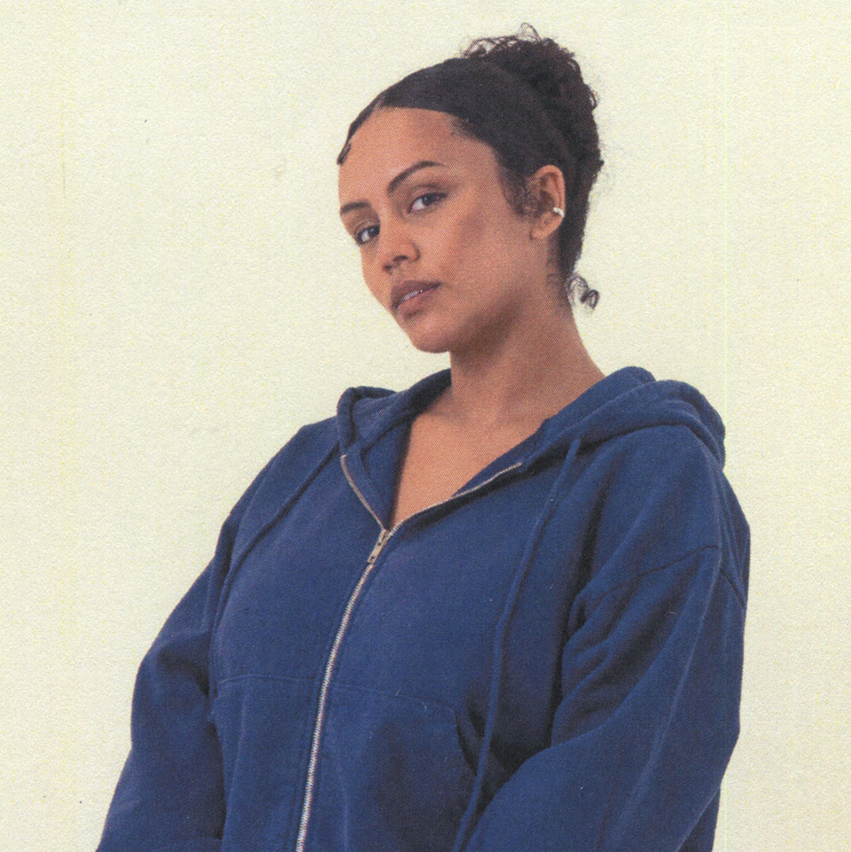 Woman wearing a Washed Navy Trash Zip Up Hoodie against a plain background.