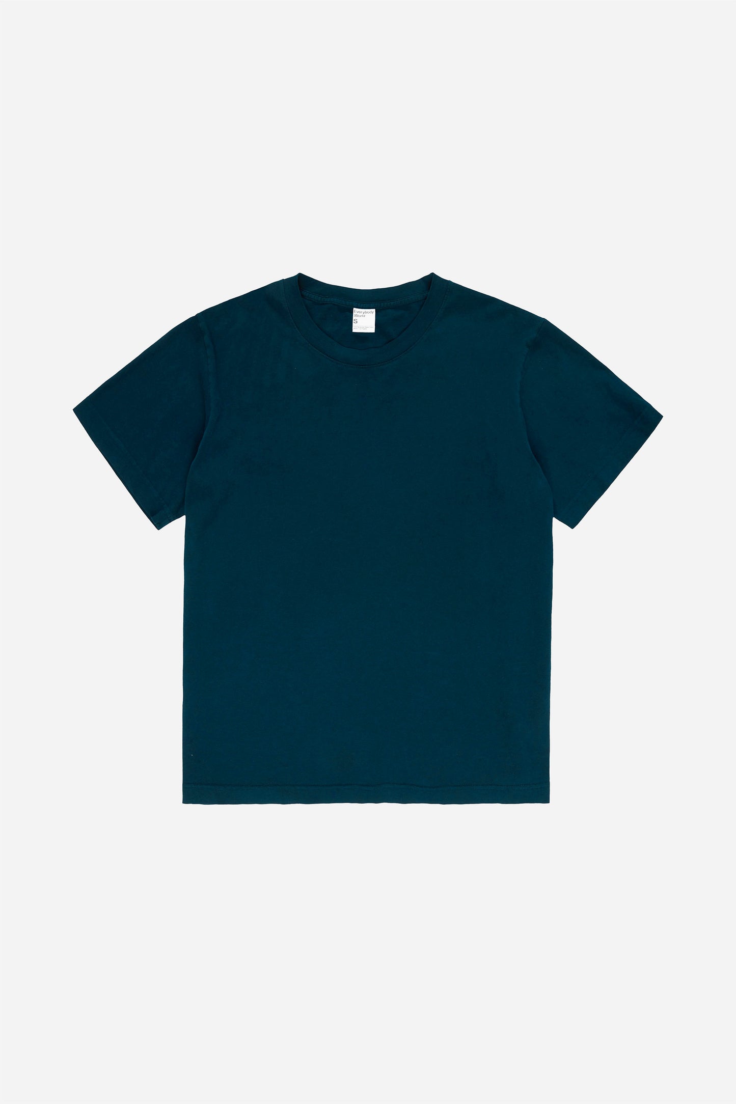Flat lay of the Short Sleeve Trash Tee in Juniper, showing the classic cut of the dark teal  garment.