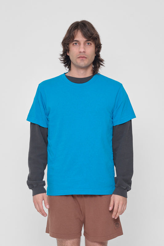 A 6'2" man in a size M Malibu Short Sleeve Trash Tee. Hem at the lower hip.