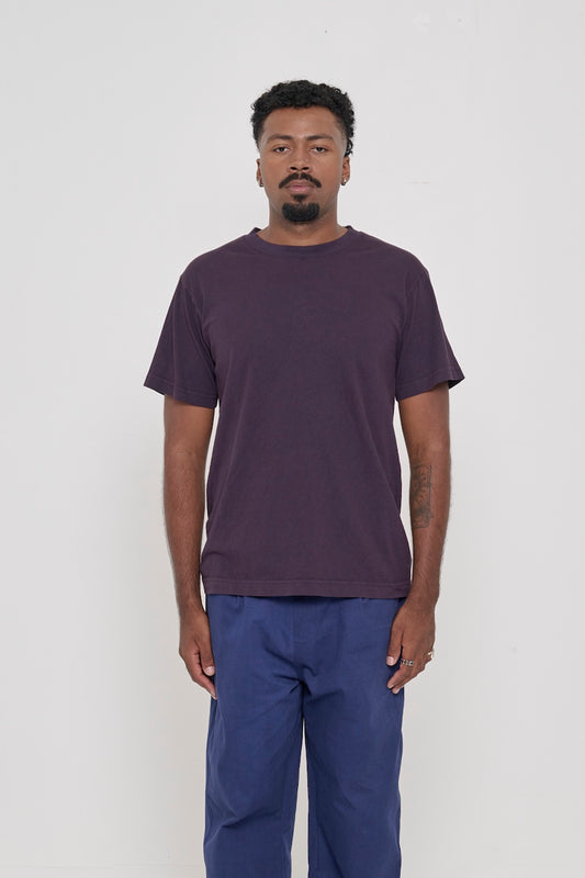 A 6'2" man in a size M Short Sleeve Trash Tee in Mulberry. Hem at the lower hip.