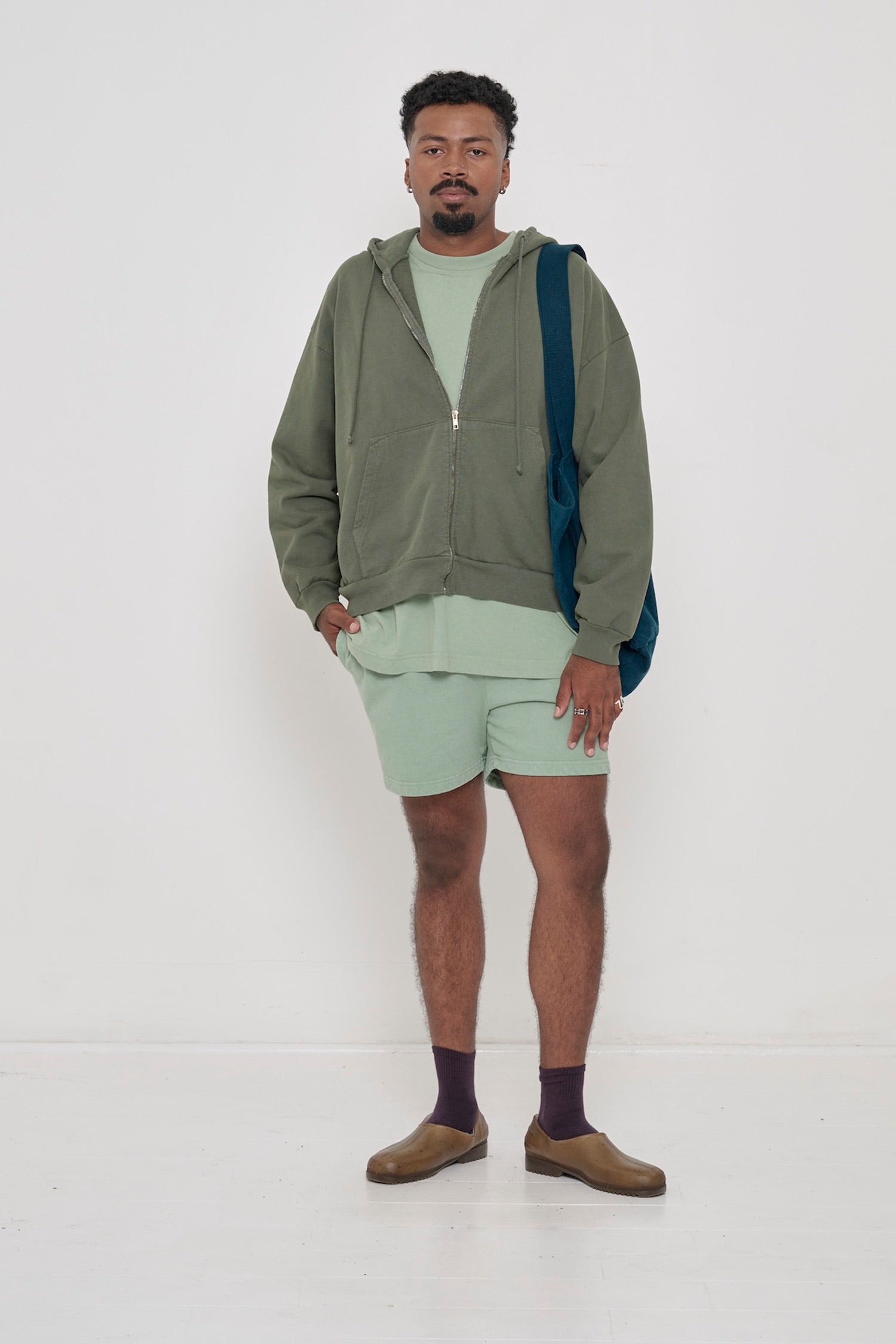 Front view of a man wearing the Short Sleeve Trash Tee in Wasabi, with a pair of Wasabi Trash Fleece Everyday Shorts.