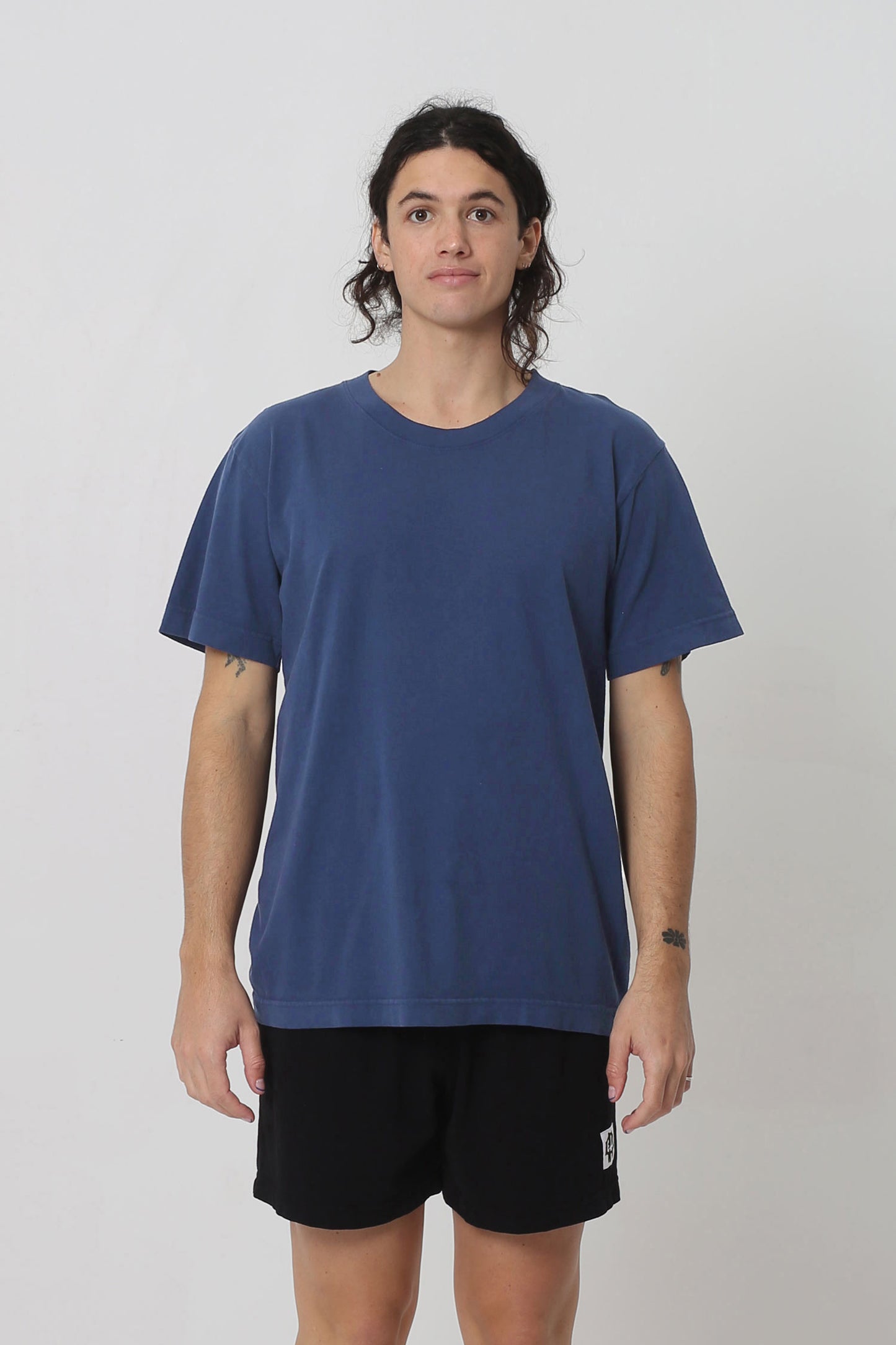 6' person in a size M Washed Navy Short Sleeve Trash Tee. Hem ends at their lower hip.