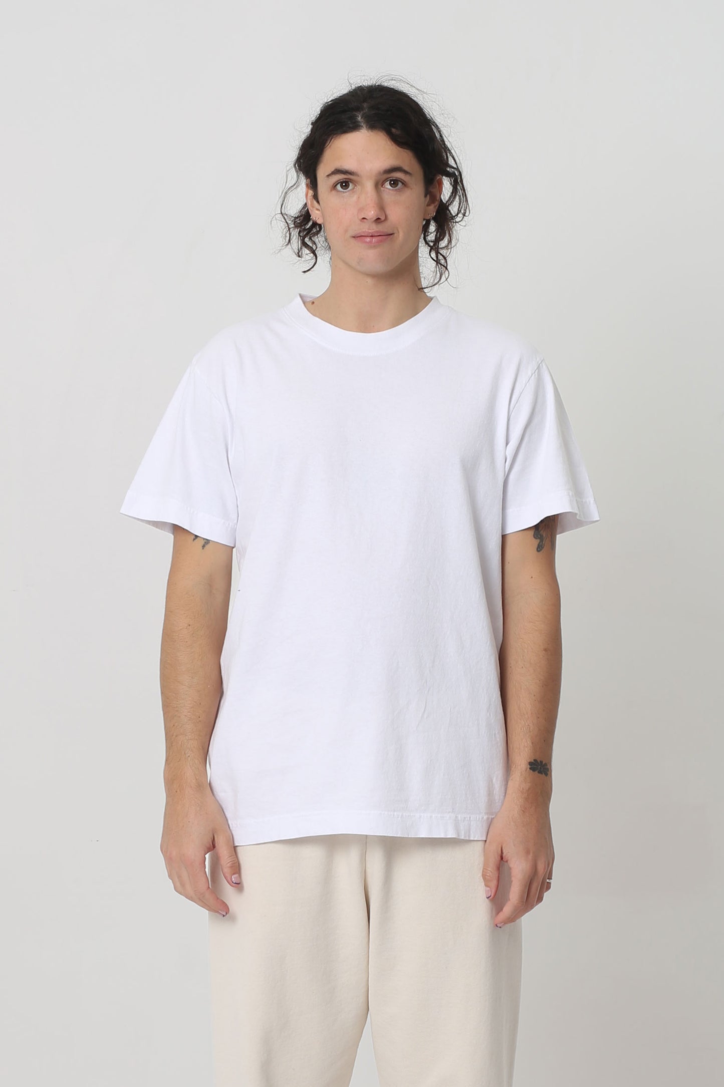 6' person in a size M White Short Sleeve Trash Tee. Hem ends at their lower hip.