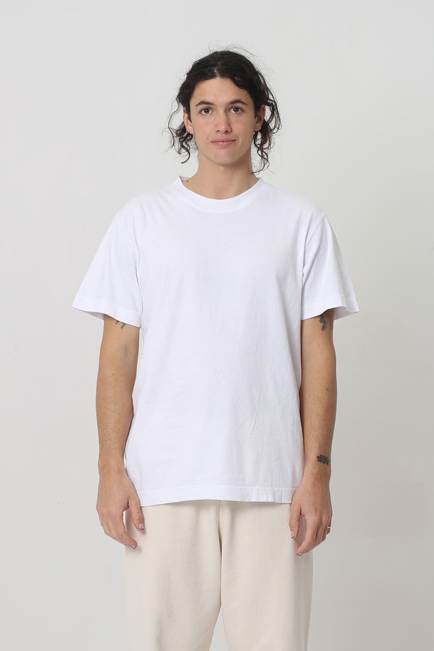 6' person in a size M White Short Sleeve Trash Tee. Hem ends at their lower hip.