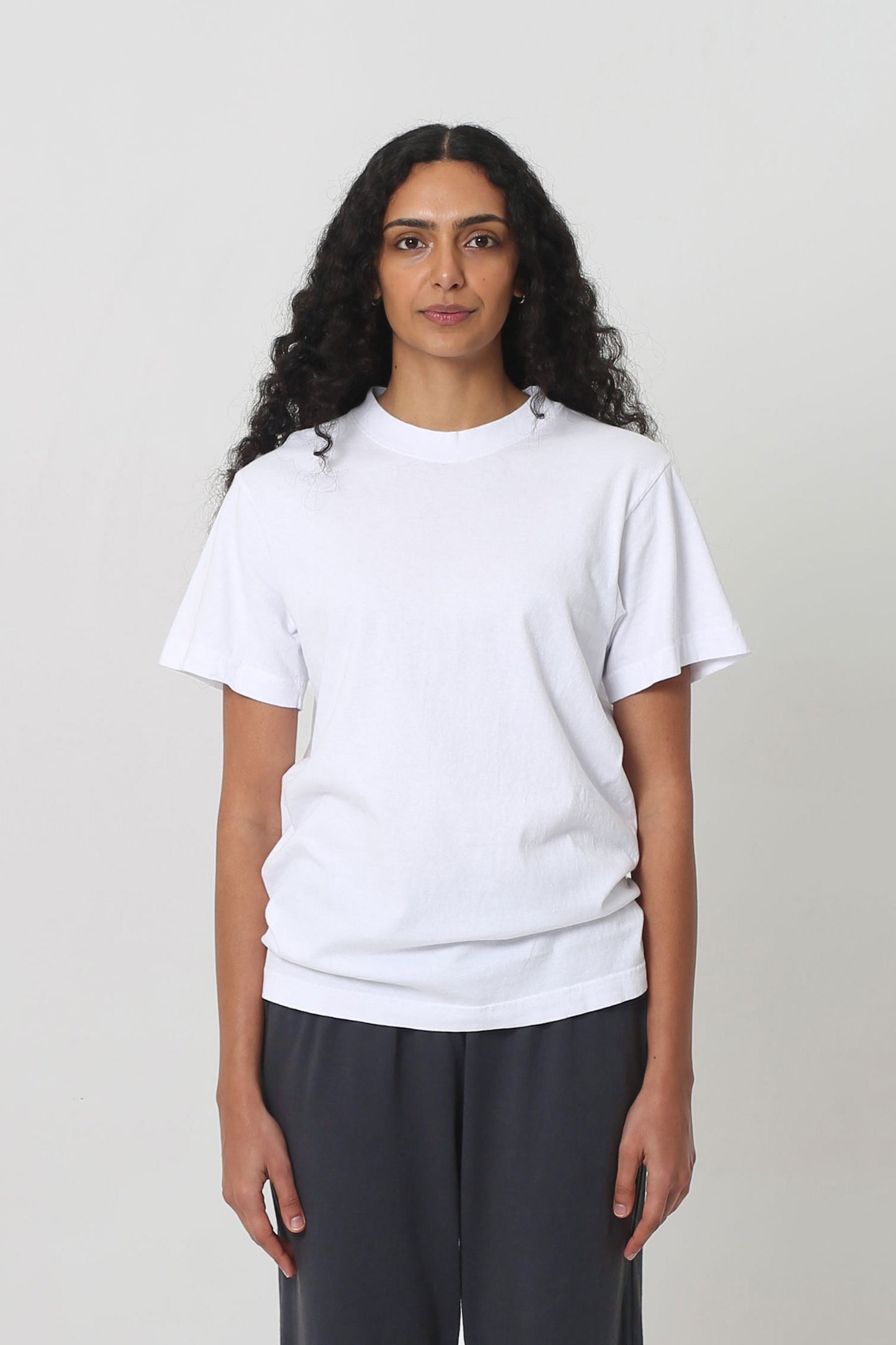 5'10" woman in a size S White Short Sleeve Trash Tee, scrunched up at the hip.