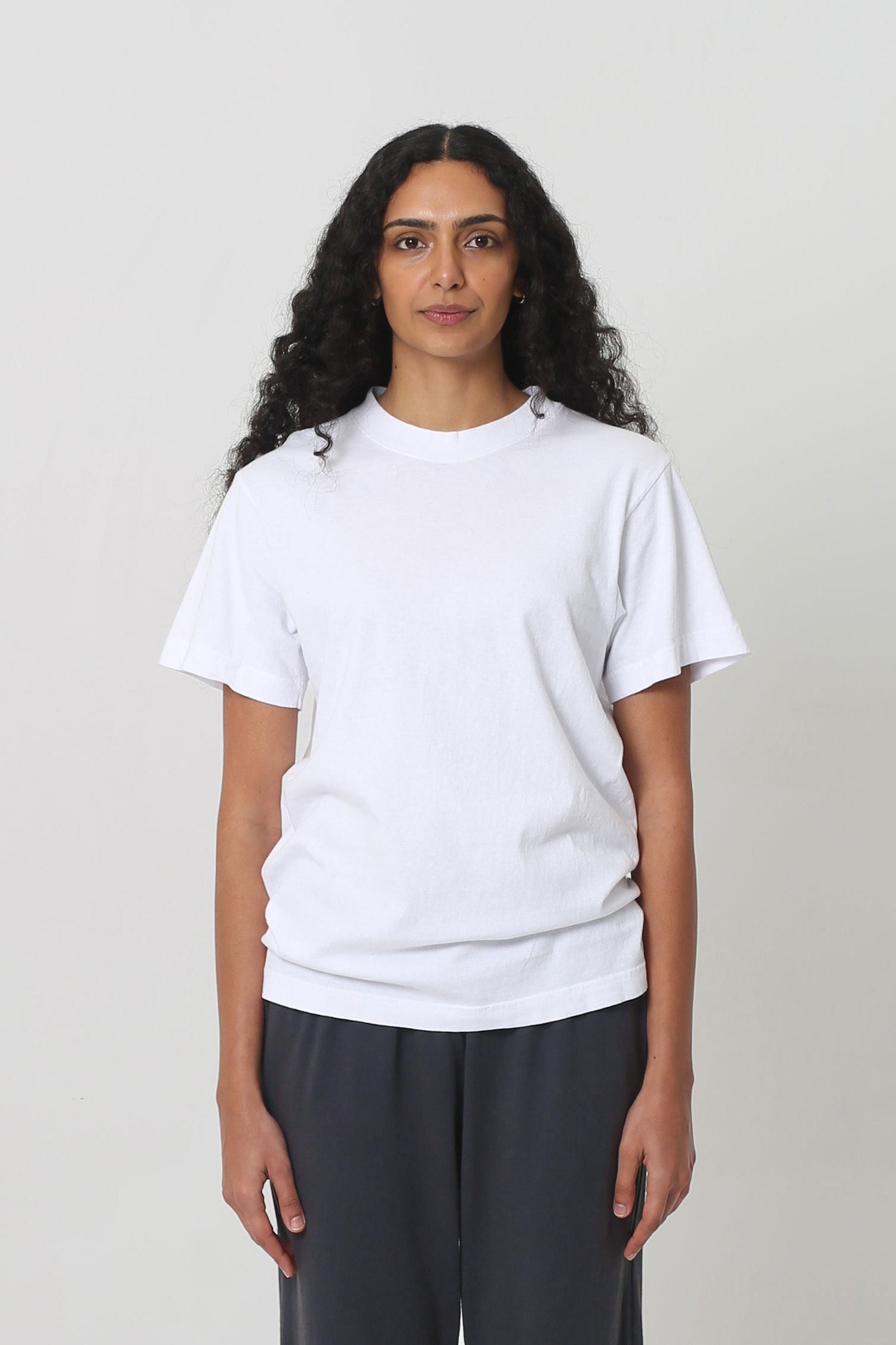 5'10" woman in a size S White Short Sleeve Trash Tee, scrunched up at the hip.