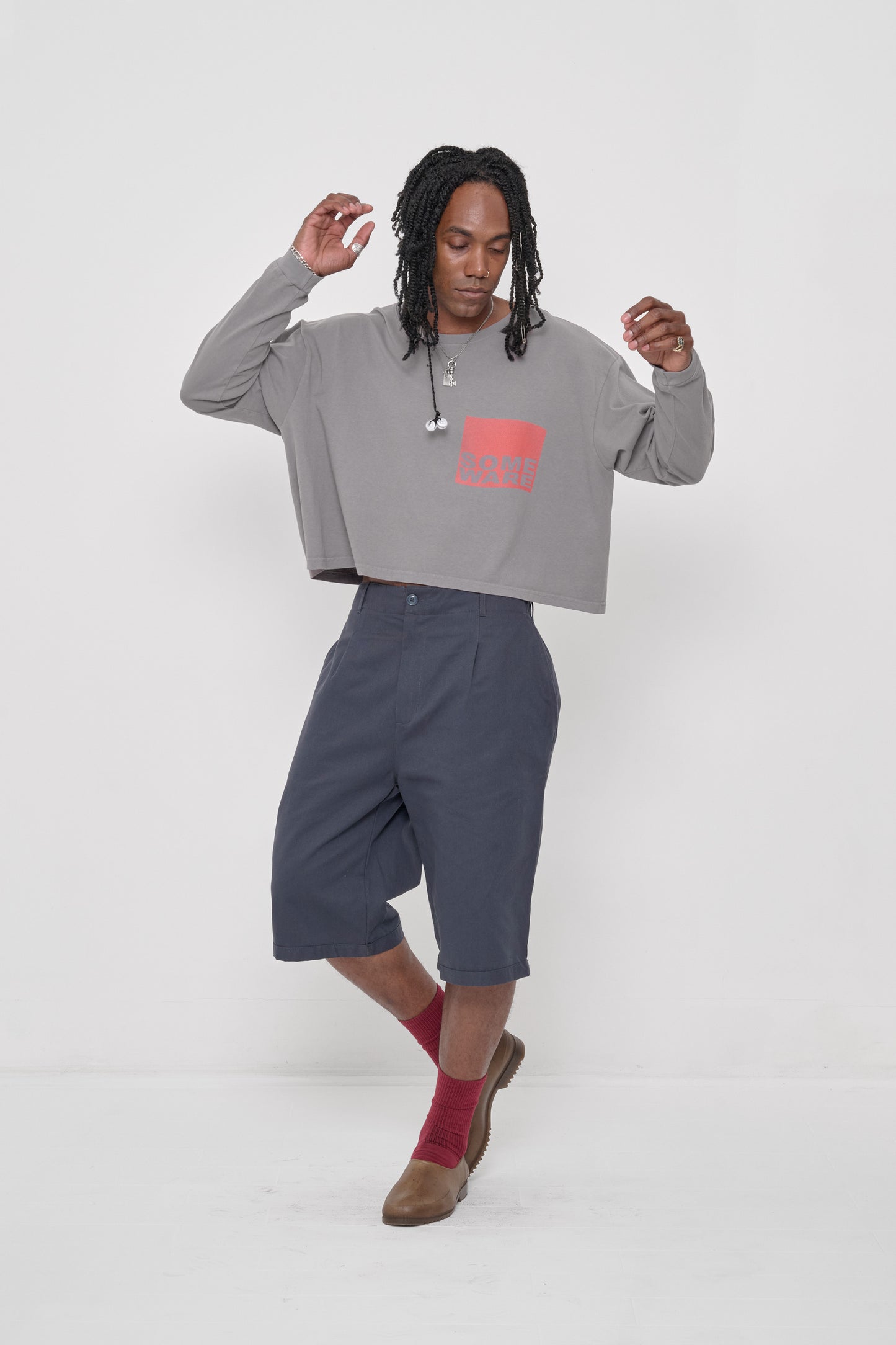 SW201 New Logo in Stone – front view, arms raised showing boxy body of shirt