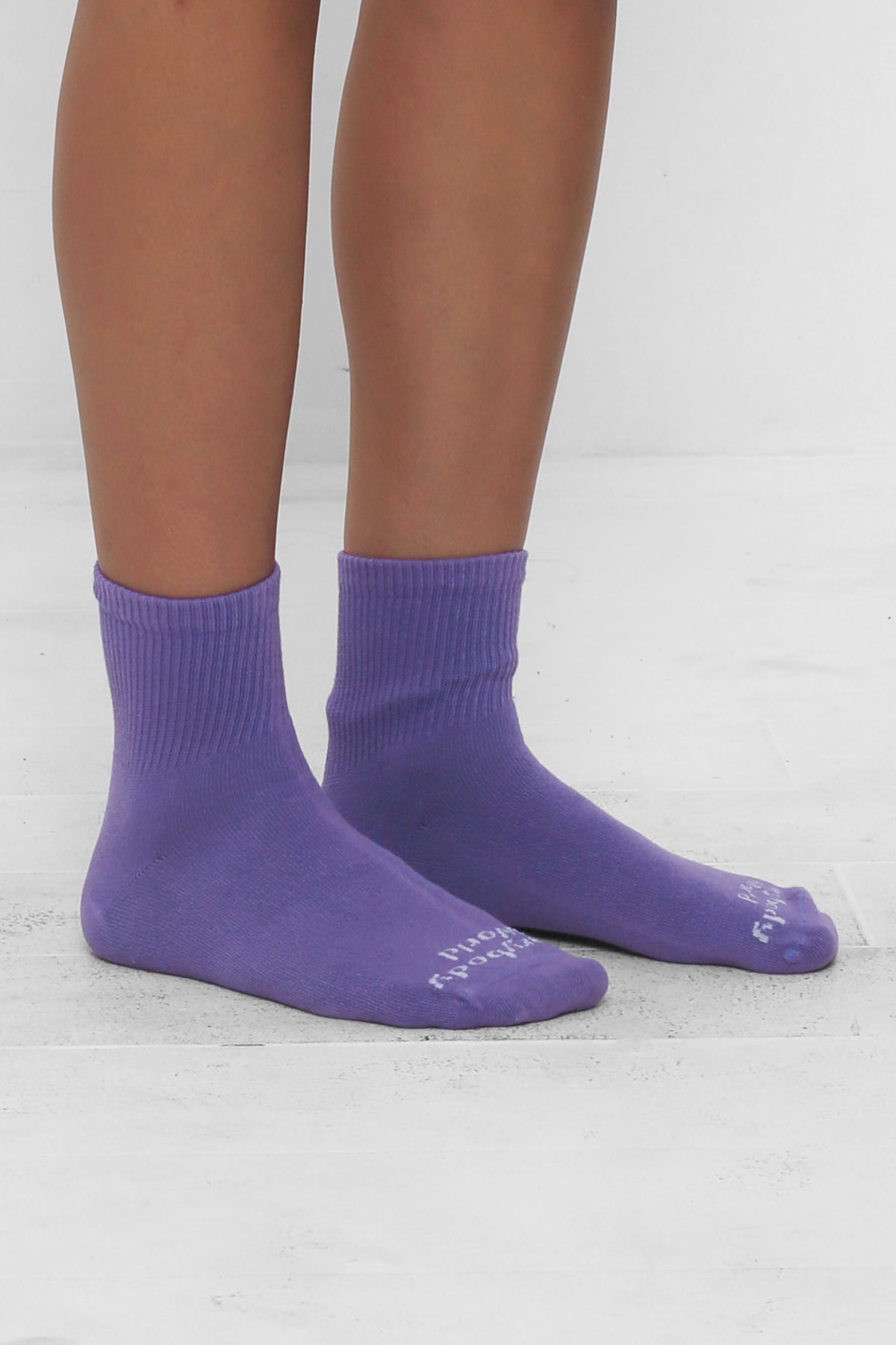 Angled view of Carpe Diem Spring Socks, branded 'Everybody.World' in white, ankle-high, shown on lower legs.