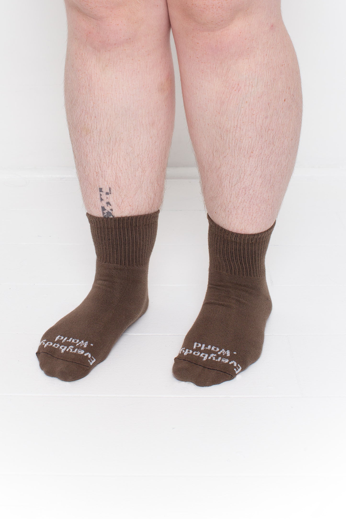 Dry Soil Spring Socks, branded 'Everybody.World,' shown on a person's lower legs pointing 45-degrees.