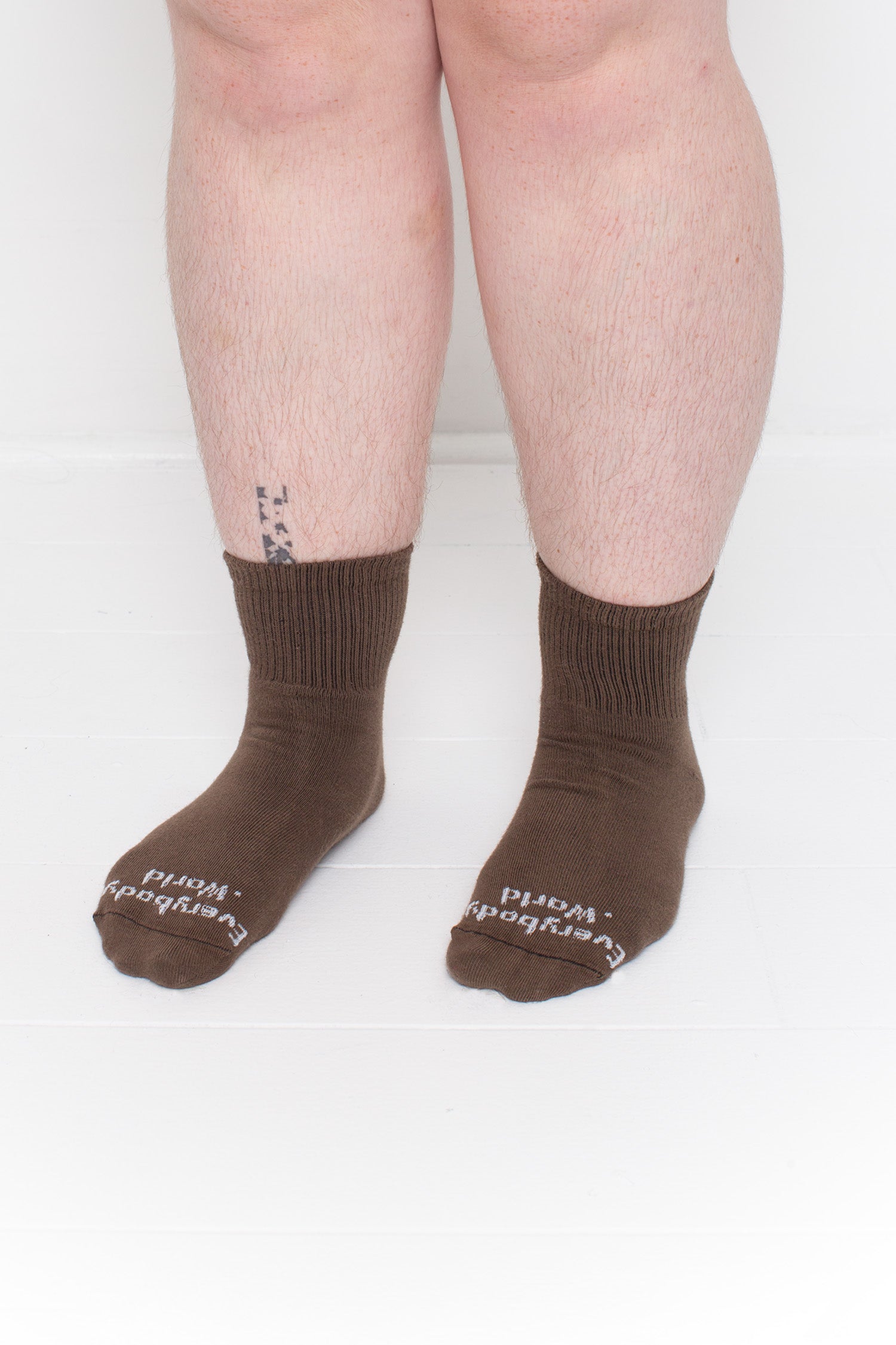 Dry Soil Spring Socks, branded 'Everybody.World,' shown on a person's lower legs pointing 45-degrees.