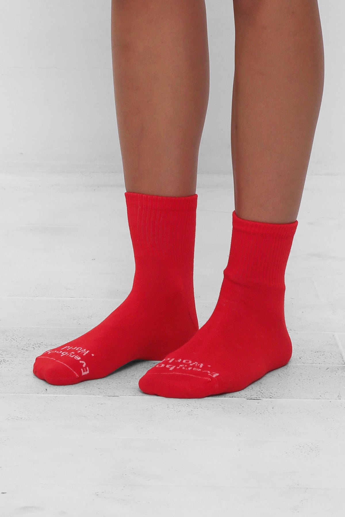 Angled view of Lava Spring Socks, branded 'Everybody.World' in white, ankle-high, shown on lower legs.