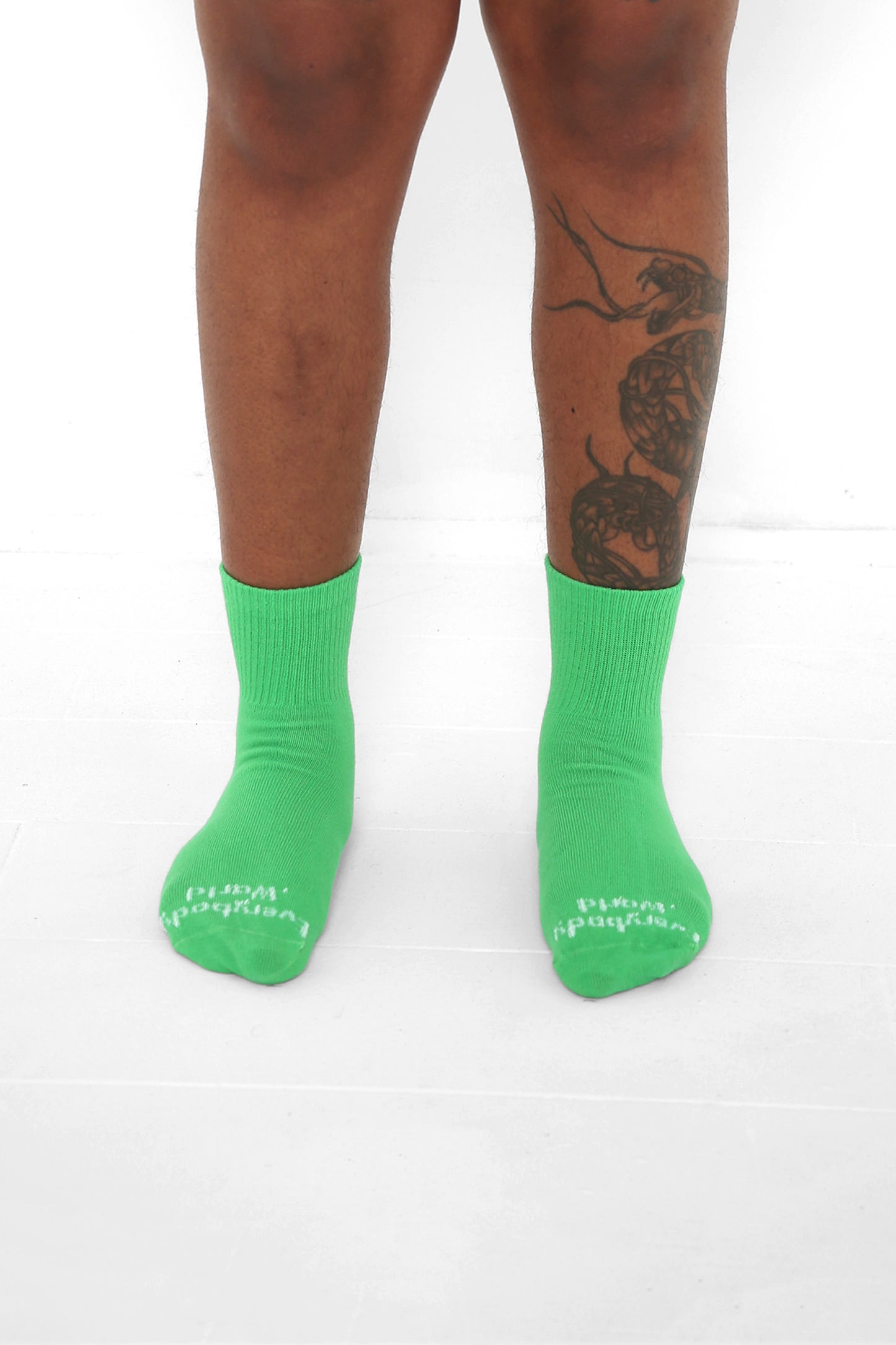 Nice Grass Spring Socks, branded 'Everybody.World' in white, ankle-high, shown on lower legs.