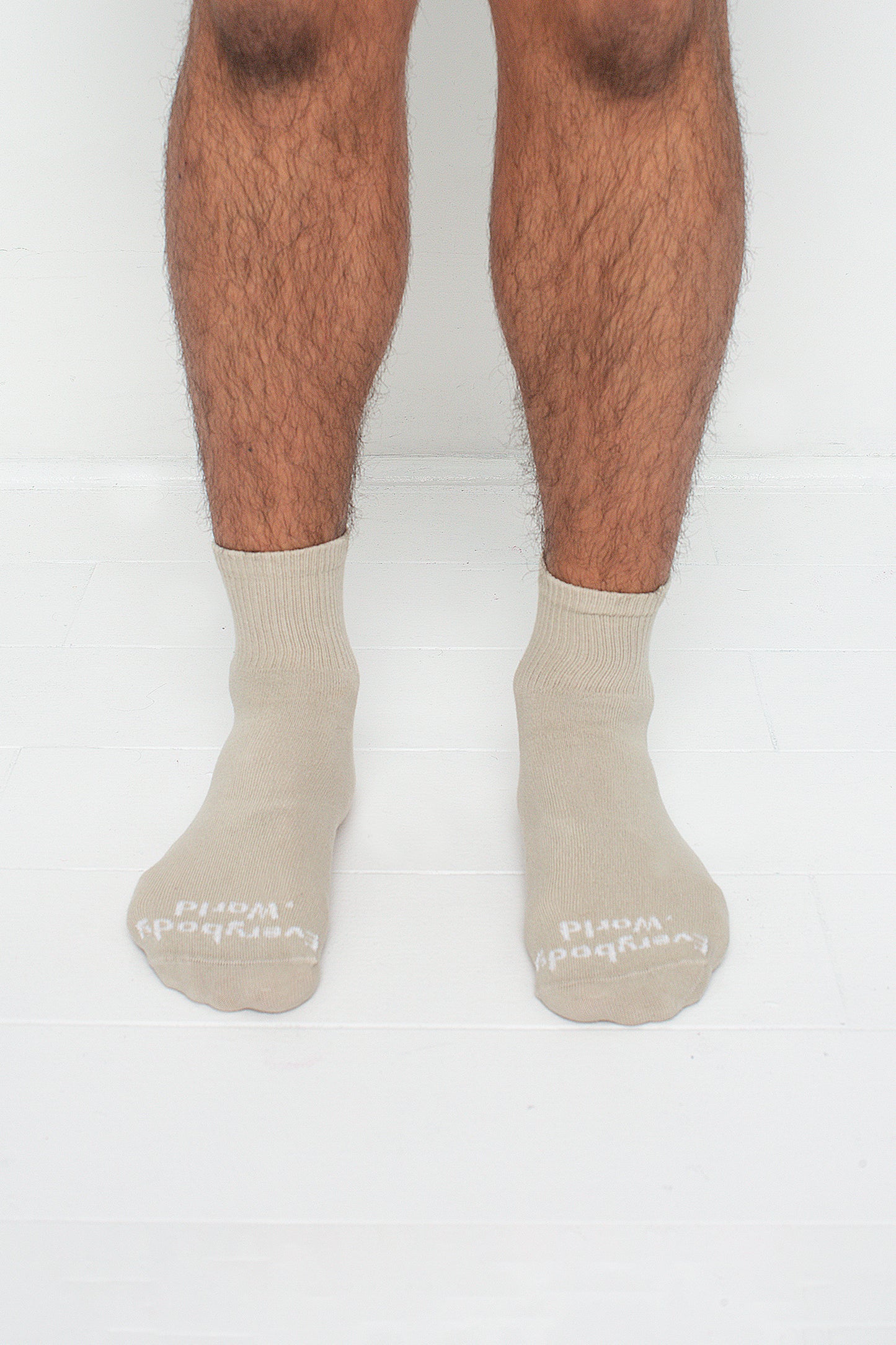 Oat Spring Socks, branded 'Everybody.World' in white, are ankle-high, shown on a person's lower legs.