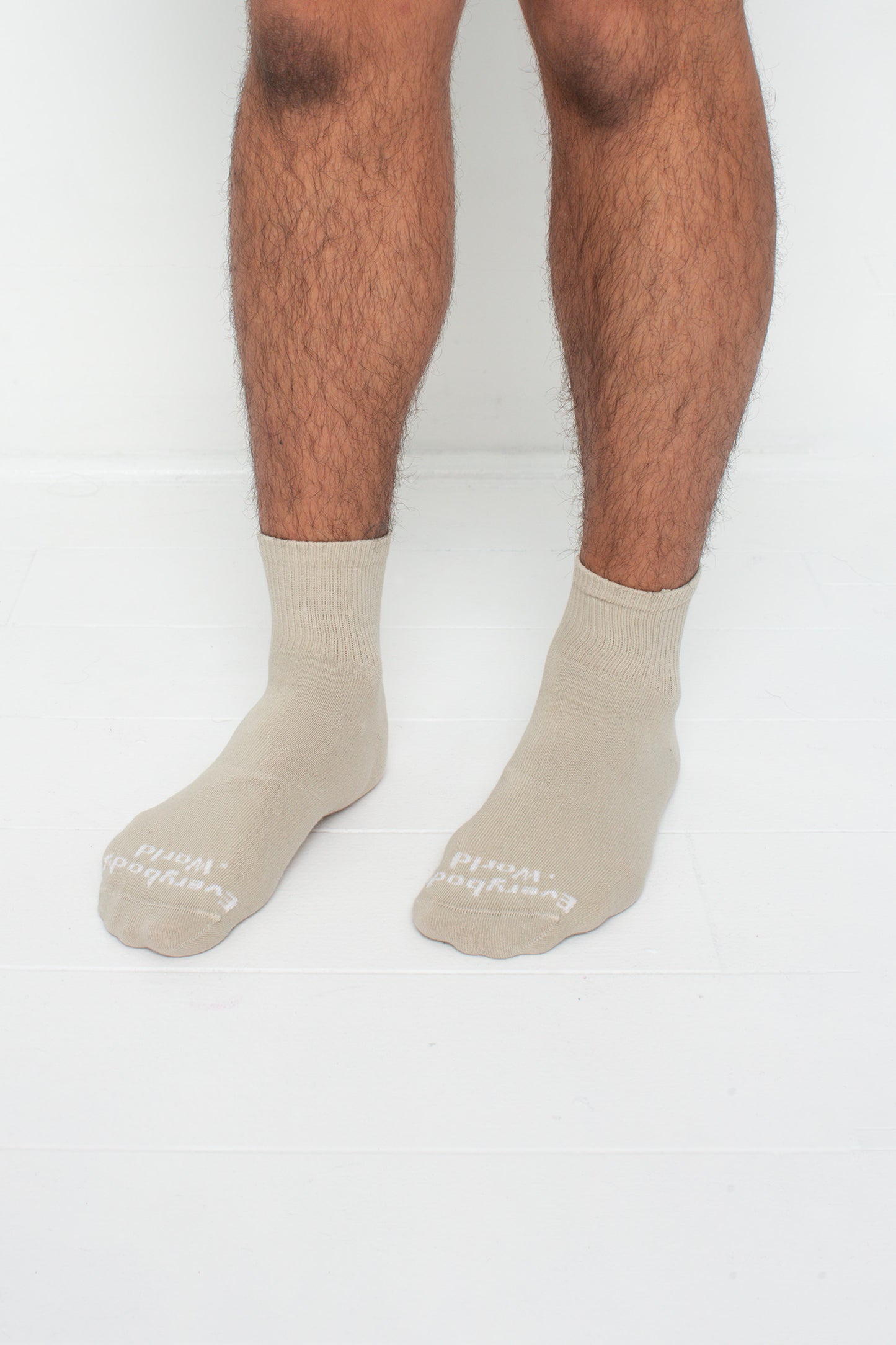 Oat Spring Socks, branded 'Everybody.World,' shown on a person's lower legs pointing 45-degrees.