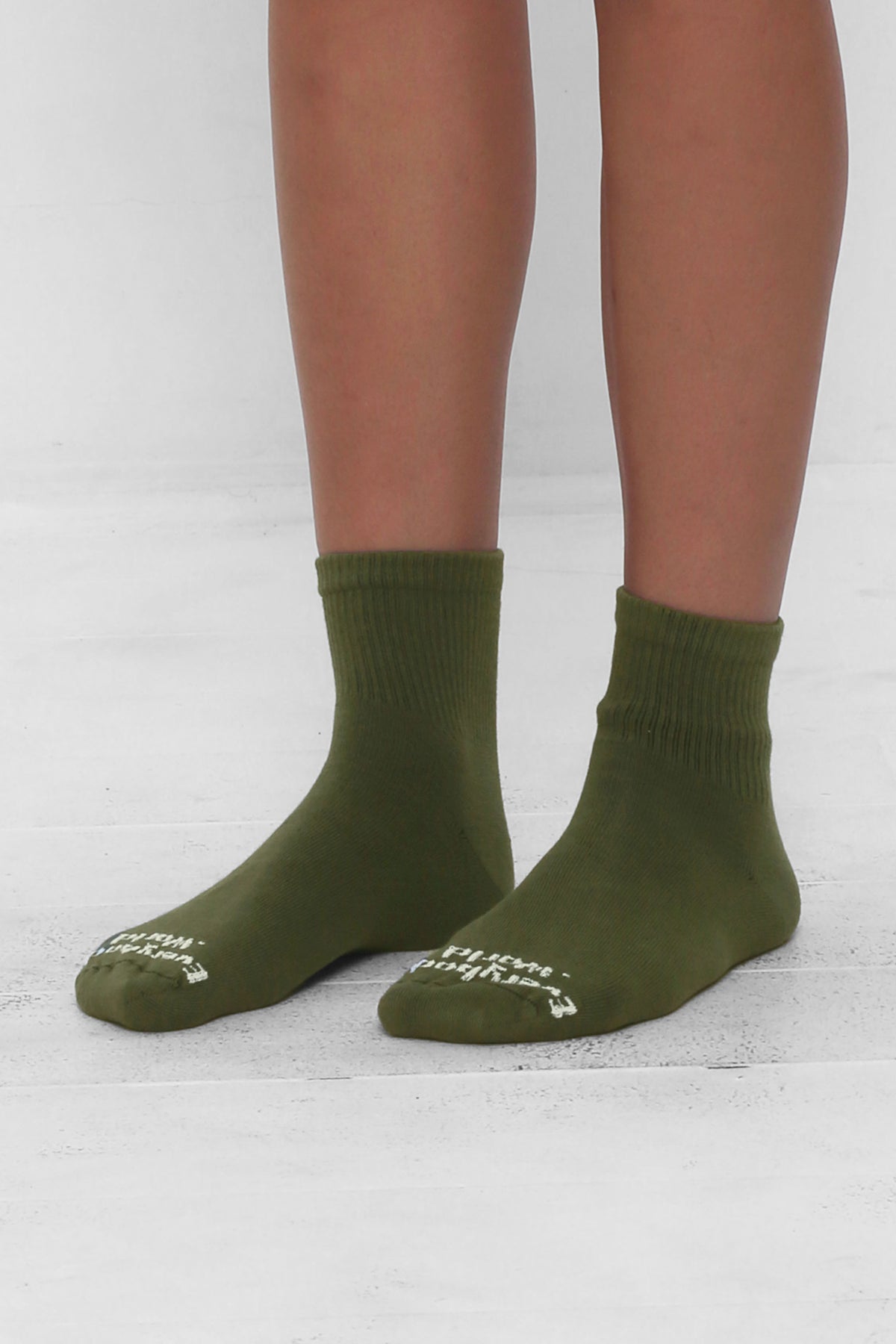 Olive Spring Socks, branded 'Everybody.World' in white, ankle-high, shown on lower legs.
