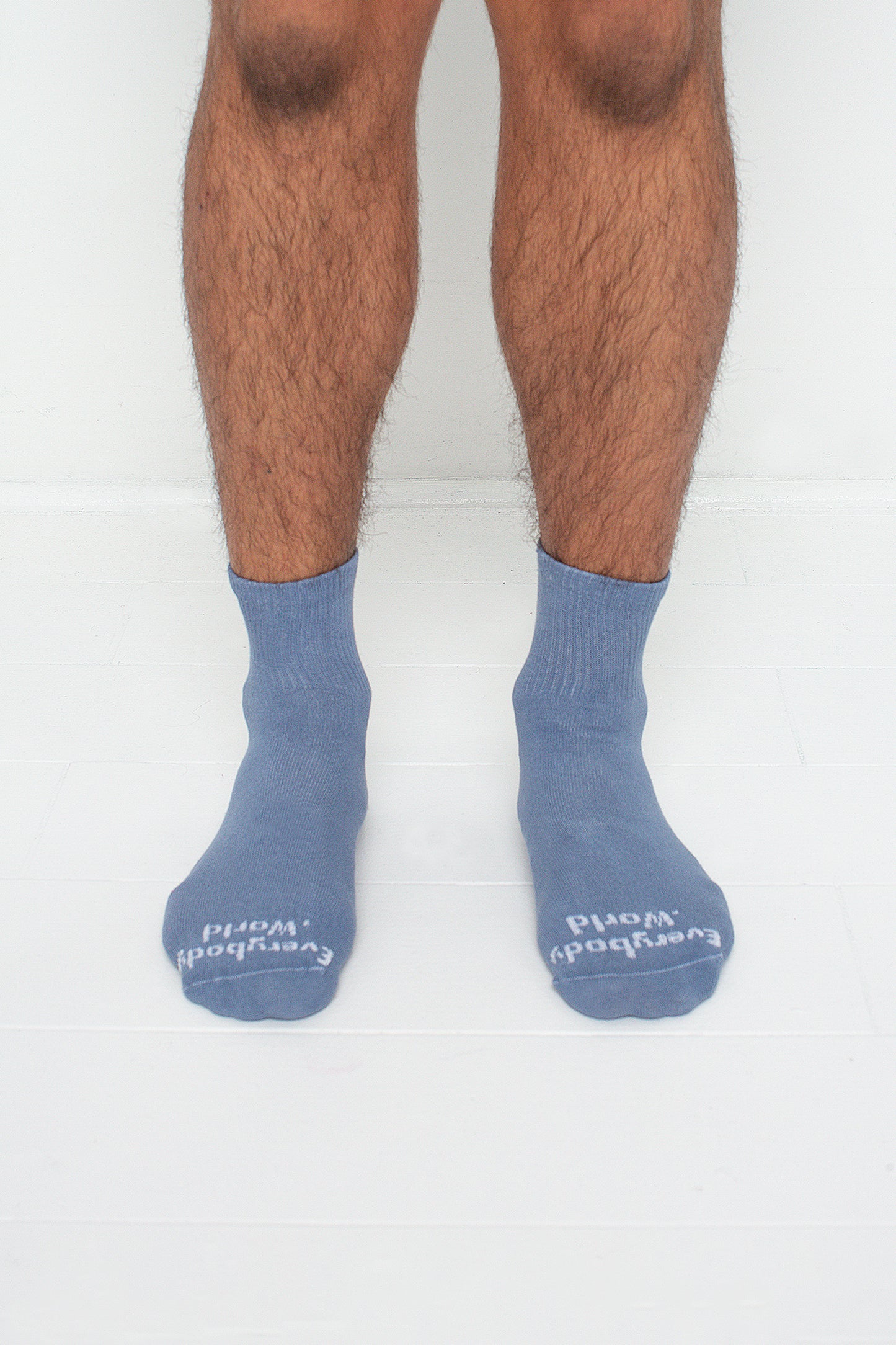 Periwinkle Spring Socks, branded 'Everybody.World' in white, are ankle-high, shown on a person's lower legs.