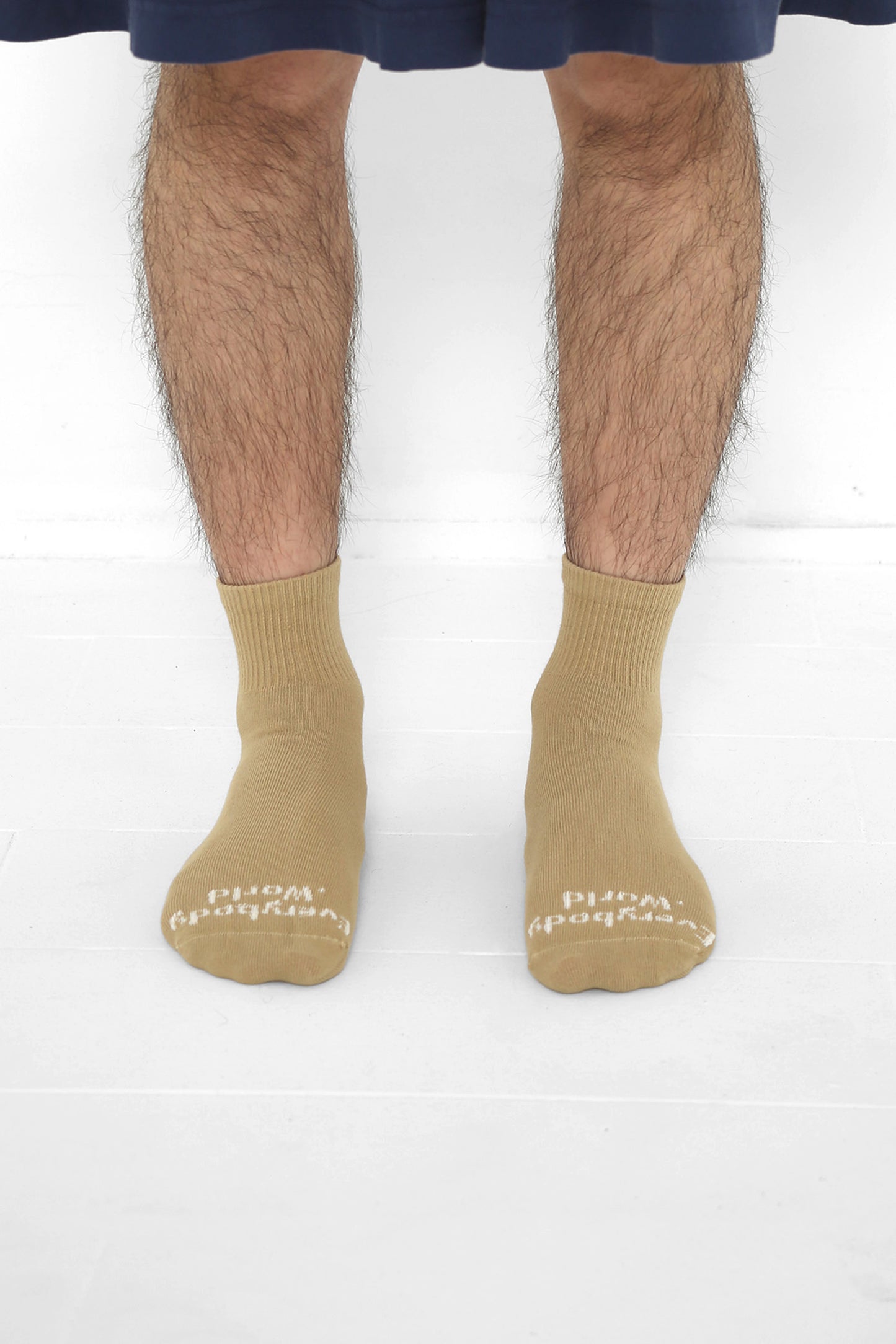 Sand Storm Spring Socks, branded 'Everybody.World' in white, ankle-high, shown on lower legs.