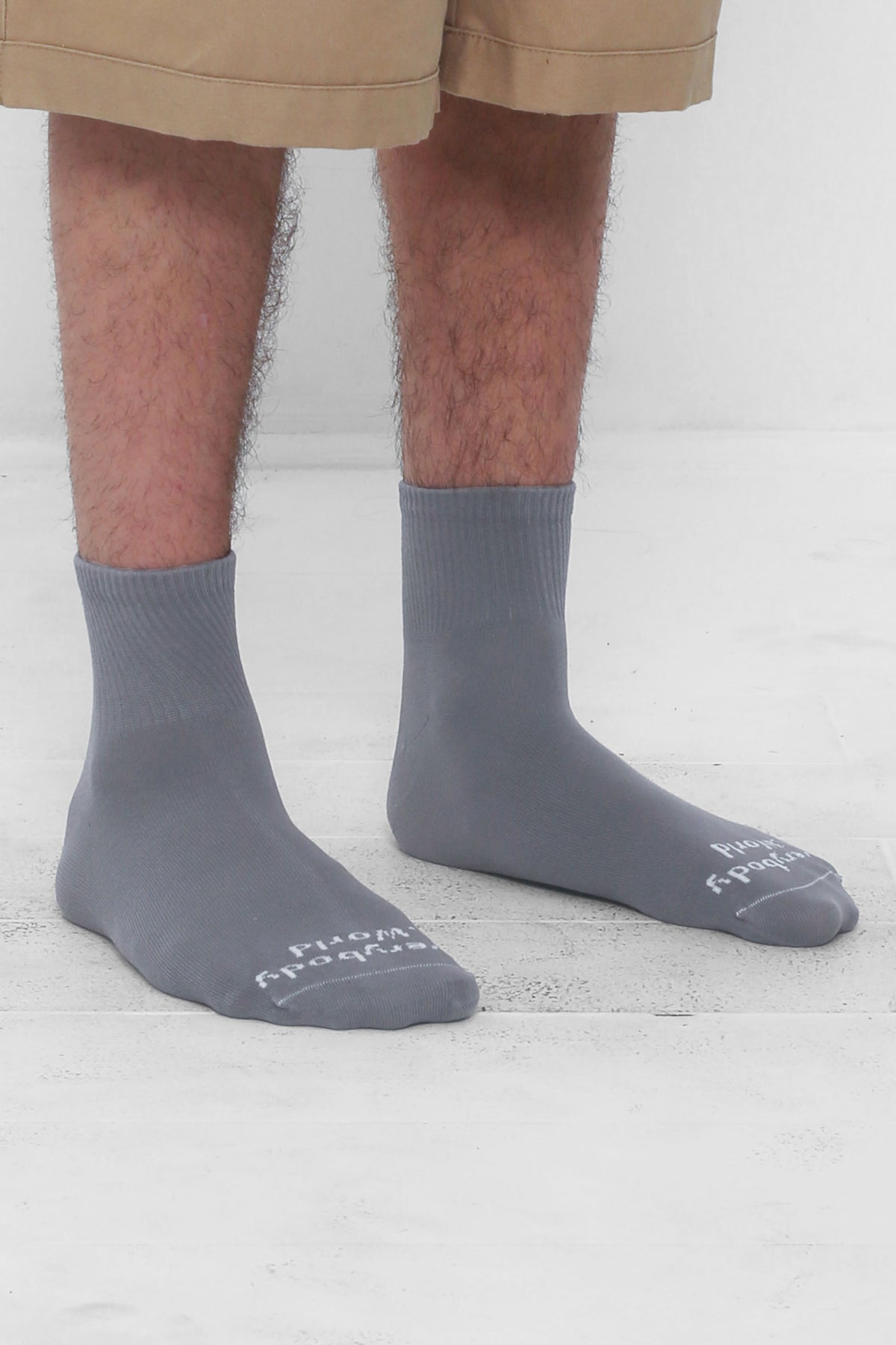 Angled view of Stone Spring Socks, branded 'Everybody.World' in white, ankle-high, shown on lower legs.