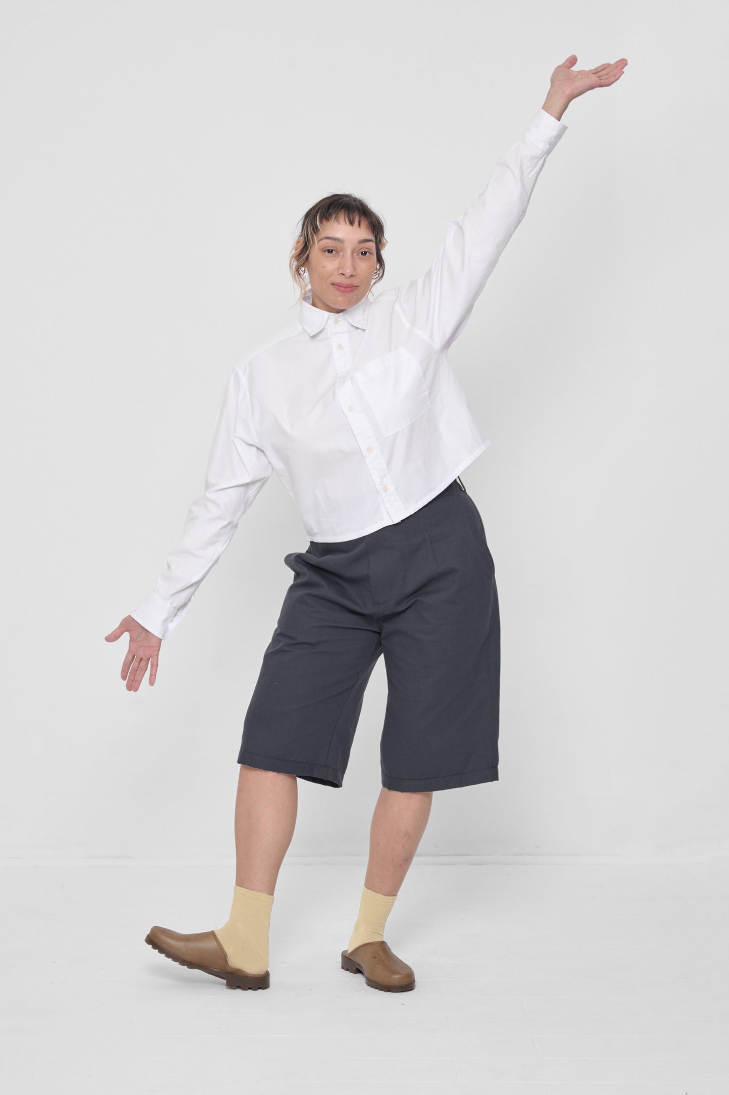 Styled with White Cropped Button-Up Shirt and Slate Bermuda Shorts.